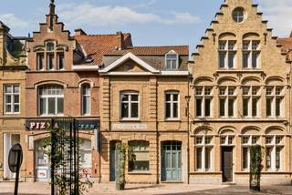 Op een toplocatie in de Rijselstraat bevindt zich deze charmante herenwoning boordevol karakter. Vanuit de woning geniet u van een prachtig zicht op de indrukwekkende Sint-Pieterskerk, terwijl u zich op wandelafstand bevindt van alle voorzieningen die het stadscentrum te bieden heeft.<br /><br />Bij het betreden van de woning komt u in de gezellige leefruimte, gevolgd door een aparte eetplaats en een volledig ingerichte keuken. De badkamer is uitgerust met een dubbel lavabomeubel en een ruime inloopdouche. Daarnaast beschikt de woning over een praktische kelder.<br /><br />Een absolute meerwaarde is de smalle, inpandige garage die doorloopt tot een ruime berging en rechtstreeks toegang biedt tot de tuin. Ideaal voor het stallen van fietsen, het plaatsen van vuilnisbakken of het opbergen van tuinmateriaal.<br /><br />Via de authentieke trappenhal bereikt u de eerste verdieping, waar zich twee bijzonder ruime slaapkamers bevinden. Op de tweede verdieping is momenteel een derde slaapkamer ingericht, met de mogelijkheid om eenvoudig een vierde slaapkamer te creëren.<br /><br />Buiten geniet u van een volledig afgesloten, zonnige stadstuin met een handige buitenberging – een heerlijke plek om in alle rust te ontspannen.<br /><br />Bent u op zoek naar een karaktervolle herenwoning met veel ruimte, authentieke elementen, een zonnige tuin en een unieke ligging met prachtig zicht op de Sint-Pieterskerk? Dan is deze woning beslist een bezoek waard!