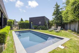 De hoeveDeze charmante langgevelhoeve, gelegen op een ruim perceel van maar liefst 1.744 m², straalt een tijdloze charme en karakter uit. Met een bouwjaar dat teruggaat tot ergens tussen 1875 en 1899, heeft deze hoeve een geschiedenis die voelbaar is in elk van de open en lichtrijke woonvertrekken. De combinatie van deze authentieke elementen met een moderne en klassevolle afwerking, geeft het geheel een unieke uitstraling en garandeert u een exclusieve woonervaring in het groen. De liggingDeze schitterende hoeve is gelegen in het rustige Rotem, een dorp binnen Dilsen-Stokkem, op een steenworp van de grens met Nederland. U geniet er van de rust en sereniteit van het platteland en bevindt zich bovendien vlakbij natuurgebied Bergerven. De Rijksweg brengt u daarbovenop op een vlotte manier naar Maaseik, Maasmechelen of andere omliggende steden.De praktijkruimtesOp het gelijkvloers treft u een verzorgde wachtruimte met gastentoilet en twee daarbij behorende spatieuze praktijkruimtes, wat deze eigendom ideaal maakt voor het uitoefenen van uw vrije beroep. U kan de hoogwaardig afgewerkte ruimtes uiteraard ook inzetten als burelen.De leefruimteIn de opengetrokken, riante woonkamer stroomt het natuurlijke daglicht binnen via de grote glaspartijen die zich langs elke zijde van de ruimte bevinden, en creëren de hoge plafonds een tastbaar gevoel van ruimte. De aanpalende veranda, die uitkomt op het terras met buitenbar, is een heerlijk gezellige ruimte om te ontspannen met zicht op de tuin. De keukenEen toonbeeld van luxe en comfort is de hypermoderne, volledig uitgeruste keuken waar het uitzonderlijk ruime kookeiland met bargedeelte het centrale middelpunt vormt. De combinatie van functionaliteit en esthetiek komt naar boven in de ingemaakte, hoogkwalitatieve keukenapparatuur, de ingebouwde opbergkasten en de uitgekiende lichtarmaturen. Schuifdeuren geven u een directe toegang tot een deel van het terras en de tuin. De slaapkamersVia de nachthal op de eerste verdieping bereikt u de twee ruime en volwaardige slaapkamers, elk voorzien van een magnifieke parketvloer en genietend van een stijlvolle, hedendaagse afwerking. De logeerkamer kan uiteraard perfect fungeren als ruime, derde slaapkamer. De badkamerIn de prachtig afgewerkte badkamer met vrijstaand ligbad en ingemaakt wasmeubel kan u terecht voor een rustgevende en luxueuze wellness-ervaring. De keuze voor natuurlijke materialen zoals hout en natuursteen werkt samen met het zachte kleurenpalet, om het hoogste niveau van ontspanning te bereiken. De troevenTalloze troeven maken van deze hoeve een uitzonderlijke vondst: de hedendaags ingerichte praktijkruimtes, de klassevolle en functionele indeling, en de ruime tuin met berging, terras, bar en ingebouwd zwembad zijn er slechts enkele van.Uw wagens kan u kwijt op de ruime oprit.