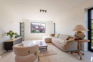 <p><strong>Volledig gerenoveerde villa met vier slaapkamers, gastenverblijf en zuidwestgerichte tuin aan de groene rand van Ravels. Aan de rand van Ravels, vlak bij de uitgestrekte Staatsbossen en op fietsafstand van het centrum, bevindt zich deze volledig gerenoveerde villa. De woning combineert een stijlvolle afwerking met bijzonder veel ruimte en hedendaags wooncomfort. Met onder meer vier slaapkamers, twee badkamers, een lichtrijke leefruimte met open designkeuken, een afzonderlijke kantoorruimte, een ruime garage en een instapklaar gastenverblijf is dit een uitzonderlijk veelzijdige eigendom. EPC label A</strong></p>
<p><strong>Gelijkvloerse verdieping</strong></p>
<p>De uitnodigende inkomhal met gastentoilet, sfeervolle indirecte verlichting en stijlvolle trappenhal verleent toegang tot de leefruimte. De woonkamer baadt dankzij de grote raampartijen in het natuurlijke daglicht. De ruime zithoek bevindt zich aan de straatzijde en biedt een aangenaam uitzicht op zowel de voortuin als de zijtuin. Centraal tussen de zithoek en de keuken ligt de eetkamer. amerhoge, dubbel opendraaiende deuren zorgen hier voor een rechtstreekse verbinding met de tuin en creëren een mooi samenspel tussen binnen en buiten. De open designkeuken is een absolute blikvanger. Ze werd uitgevoerd met gefineerde eiken kasten en binnenkasten in bijpassende kleur. De keuken is volledig uitgerust met een inductiekookplaat met geïntegreerde afzuiging in het werkblad, een vaatwasser, koelkast, afzonderlijke diepvriezer, spoelbak en oven. Het ruime composieten werkblad sluit naadloos aan bij het stijlvolle maatwerk. Dankzij de doordachte oriëntatie behoudt u tijdens het koken en tafelen contact met uw gezin of gasten en heeft u zicht op de oprit. Via de afzonderlijke zijingang bereikt u rechtstreeks de kantoorruimte. Deze toegang is voorzien van maatwerkkasten die dienstdoen als vestiaire en extra bergruimte, waardoor werken aan huis perfect mogelijk is zonder de privacy van de leefruimtes te verstoren. Een centrale gang vormt een rustig verbindingspunt tussen de leefruimte en het kantoor en geeft toegang tot twee ruime slaapkamers. Op deze verdieping bevindt zich bovendien een douchekamer, een afzonderlijk toilet en een praktische ruimte met aansluitingen voor een wasmachine en droogkast. De volledige gelijkvloerse verdieping is uitgerust met vloerverwarming. De aanwezige airconditioning zorgt tijdens de zomer voor aangename verkoeling en kan in de tussenseizoenen eveneens worden gebruikt om bij te verwarmen.</p>
<p><strong>Verdieping<br /></strong>Ook de bovenverdieping straalt rust en luxe uit. De natuurstenen vloer werd mooi doorgetrokken en versterkt het harmonieuze geheel. Hier bevinden zich twee ruime slaapkamers, die opengewerkt zijn tot in de nok van het dak en daardoor een bijzonder ruimtelijk karakter hebben. De stijlvolle badkamer is ingericht als een echte wellnessruimte en beschikt over een ruime inloopdouche, toilet en een dubbele wastafel met verlichte spiegel en praktische softclose-lades. Ook hier zijn aansluitingen voor een wasmachine en droogkast voorzien.</p>
<p><strong>Gastenverblijf en buitenruimte<br /></strong>Een bijzonder leuke verrassing is het afzonderlijke gastenverblijf achteraan in de tuin. Dit instapklare tiny house is bereikbaar via de tuin en vormt de ideale plek voor logés, inwonende kinderen, een hobbyruimte of een rustige werkplek. De verzorgde tuin is gunstig georiënteerd op het zuidwesten en biedt volop mogelijkheden om in alle rust van de zon en de groene omgeving te genieten. Daarnaast beschikt de woning over een ruime garage. De villa werd grondig en volledig vernieuwd en is onder meer voorzien van zonnepanelen, vloerverwarming en airconditioning in de leefruimte en slaapkamers. <br /><br />Bijzonderheden:<br />- Landelijke omgeving <br />- Volledig gerenoveerd, A label <br />- Zonnepanelen, Airco's <br />- Kindvriendelijke omgeving - op wandelafstand van natuurgebied Gewestbossen Ravels<br /><br /></p>
<p></p>
