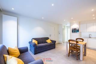 Dit pand werd volledig vernieuwd in 2021 (eveneens al het raamwerk) en is bijgevolg direct instapklaar. <br /><br />Bij het binnenkomen stappen we direct de lichtrijke woonkamer in waar ook de nieuwe, compleet afgewerkte &amp; ingerichte keuken is vervat. De douchekamer is voorzien van hangtoilet, wastafel, douche en handdoekenradiator. De 1ste slaapkamer is voldoende ruim; de 2de slaapkamer is voorzien van een enkel bed en inbouwkasten. <br /><br />Dit appartement werd netjes in het wit opgeschilderd en is voorzien van elektrische rolluiken.<br />Gunstige EPC-waarde: 146 (Label B). Gemeubeld. Lage syndicuskosten wegens geen lift.<br /> 