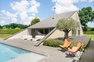 À la lisière du quartier résidentiel de Bosmolens, à quelques pas du domaine provincial Wallemote/Wolvenhof et à proximité immédiate des accès autoroutiers d'Izegem ainsi que de l'hôpital AZ Delta, se trouve cette superbe villa d'architecte prête à emménager, implantée sur un terrain de 1.897 m².<br /><br />Offrant une surface habitable de 356 m², cette propriété séduit par ses matériaux nobles tels que le teck, la pierre naturelle et l'inox. Les larges baies vitrées, les généreuses hauteurs sous plafond et l'architecture soigneusement pensée créent une sensation exceptionnelle d'espace, de luminosité et une parfaite harmonie entre l'intérieur et le jardin.<br /><br />Le rez-de-chaussée accueille un élégant séjour avec cheminée, ouvert directement sur la terrasse, la piscine et le pool house. Il comprend également une cuisine entièrement équipée de grand standing, un espace polyvalent pouvant servir de bureau, de profession libérale ou de chambre supplémentaire, une buanderie fonctionnelle ainsi qu'un double garage avec espace de rangement.<br /><br />À l'étage, vous découvrirez trois belles chambres, dont une spacieuse suite parentale avec dressing et salle de bains luxueuse. Une seconde salle de bains complète le confort de la famille.<br /><br />Le jardin magnifiquement aménagé, baigné de soleil, avec sa piscine entièrement rénovée et son élégant pool house comprenant un espace repas, une kitchenette et un vestiaire, constitue un véritable havre de paix où intimité et détente sont au rendez-vous.<br /><br />Une propriété d'exception alliant architecture contemporaine, finitions de prestige, confort absolu et excellente situation.