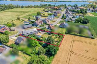 De hoeveDeze charmante langgevelhoeve, gelegen op een ruim perceel van maar liefst 1.744 m², straalt een tijdloze charme en karakter uit. Met een bouwjaar dat teruggaat tot ergens tussen 1875 en 1899, heeft deze hoeve een geschiedenis die voelbaar is in elk van de open en lichtrijke woonvertrekken. De combinatie van deze authentieke elementen met een moderne en klassevolle afwerking, geeft het geheel een unieke uitstraling en garandeert u een exclusieve woonervaring in het groen. De liggingDeze schitterende hoeve is gelegen in het rustige Rotem, een dorp binnen Dilsen-Stokkem, op een steenworp van de grens met Nederland. U geniet er van de rust en sereniteit van het platteland en bevindt zich bovendien vlakbij natuurgebied Bergerven. De Rijksweg brengt u daarbovenop op een vlotte manier naar Maaseik, Maasmechelen of andere omliggende steden.De praktijkruimtesOp het gelijkvloers treft u een verzorgde wachtruimte met gastentoilet en twee daarbij behorende spatieuze praktijkruimtes, wat deze eigendom ideaal maakt voor het uitoefenen van uw vrije beroep. U kan de hoogwaardig afgewerkte ruimtes uiteraard ook inzetten als burelen.De leefruimteIn de opengetrokken, riante woonkamer stroomt het natuurlijke daglicht binnen via de grote glaspartijen die zich langs elke zijde van de ruimte bevinden, en creëren de hoge plafonds een tastbaar gevoel van ruimte. De aanpalende veranda, die uitkomt op het terras met buitenbar, is een heerlijk gezellige ruimte om te ontspannen met zicht op de tuin. De keukenEen toonbeeld van luxe en comfort is de hypermoderne, volledig uitgeruste keuken waar het uitzonderlijk ruime kookeiland met bargedeelte het centrale middelpunt vormt. De combinatie van functionaliteit en esthetiek komt naar boven in de ingemaakte, hoogkwalitatieve keukenapparatuur, de ingebouwde opbergkasten en de uitgekiende lichtarmaturen. Schuifdeuren geven u een directe toegang tot een deel van het terras en de tuin. De slaapkamersVia de nachthal op de eerste verdieping bereikt u de twee ruime en volwaardige slaapkamers, elk voorzien van een magnifieke parketvloer en genietend van een stijlvolle, hedendaagse afwerking. De logeerkamer kan uiteraard perfect fungeren als ruime, derde slaapkamer. De badkamerIn de prachtig afgewerkte badkamer met vrijstaand ligbad en ingemaakt wasmeubel kan u terecht voor een rustgevende en luxueuze wellness-ervaring. De keuze voor natuurlijke materialen zoals hout en natuursteen werkt samen met het zachte kleurenpalet, om het hoogste niveau van ontspanning te bereiken. De troevenTalloze troeven maken van deze hoeve een uitzonderlijke vondst: de hedendaags ingerichte praktijkruimtes, de klassevolle en functionele indeling, en de ruime tuin met berging, terras, bar en ingebouwd zwembad zijn er slechts enkele van.Uw wagens kan u kwijt op de ruime oprit.