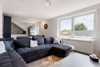 Voor meer info en foto’s, surf naar www.swevers.be – Acaciastraat 71 bus 4 in Hasselt is een gerenoveerd en instapklaar appartement op de vierde verdieping van een verzorgd gebouw uit 1980. Het appartement werd in 2024 vernieuwd en beschikt over een bewoonbare oppervlakte van 74 m². De praktische indeling omvat een inkomhal, een lichtrijke leefruimte met open keuken, twee slaapkamers, een badkamer en meerdere handige bergingen. Dankzij de grote raampartijen geniet de leefruimte van veel natuurlijke lichtinval, wat zorgt voor een aangename en open sfeer. De twee slaapkamers bevinden zich aan de rustige zijde van het appartement en kijken uit op een speelplein. De grootste slaapkamer is 12 m² groot, terwijl de tweede slaapkamer van 9 m² aansluit op een dressingruimte. De centraal gelegen badkamer is vlot bereikbaar vanuit de nachthal. Extra bergruimtes bieden voldoende plaats voor voorraad en huishoudelijke spullen. Bij het appartement hoort bovendien een private carport, ideaal voor de wagen en het stallen van fietsen. Een bijkomend voordeel op deze centrale locatie. De ligging in de Hasseltse deelgemeente Runkst is bijzonder praktisch. Het centrum ligt op slechts 900 meter, terwijl winkels, scholen, restaurants en ontspanning zich op ongeveer 500 meter bevinden. Openbaar vervoer bereikt u op circa 350 meter en de op- en afritten van de snelweg liggen op ongeveer 2 kilometer. Een ideale woonst voor wie comfortabel en centraal wil wonen, met alle dagelijkse voorzieningen op wandelafstand. Voor meer informatie, bel 011 255 155. Bron bewoonbare oppervlakte: EPC – verslag.