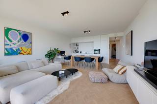 <p><strong>Op de legendarische site van de voormalige Zillion staat vandaag The Residence. En daar vind je dit instapklare appartement met een uitzicht waar je elke dag opnieuw blij van wordt: frontaal zicht op het groen, in alle rust. En als extra troeft? Het appartement heeft aan beide kanten een terras.</strong></p><p><strong>Licht, ruimte en een fantastisch zicht op groen</strong></p><p>De royale leefruimte baadt in het licht en heeft een mooie houten visgraatparket op vloerverwarming. Grote ramen geven uit op het groen, terwijl het inpandige, zuidgerichte terras er mooi op aansluit. De ideale plek voor een apero in de zon.</p><p>De open keuken vormt één geheel met de leefruimte en is volledig uitgerust met AEG-toestellen. Aan kastruimte is er alvast geen gebrek, waardoor je alles netjes kan opbergen.</p><p><strong>Een rustige plek om te slapen</strong></p><p>De hoofdslaapkamer ligt aan de achterkant van het appartement. De tweede slaapkamer doet vandaag dienst als dressing, maar kan uiteraard ook perfect als slaapkamer of bureau gebruikt worden.</p><p>Vanuit beide kamers stap je zo het tweede terras op. Hier pik je 's ochtends de eerste zon mee en kijk je uit over de daktuin.</p><p><strong>Badkamer én wasberging</strong></p><p>De ruime badkamer sluit aan op de hoofdslaapkamer en is praktisch ingericht met een douche én een bad. De aansluiting voor wasmachine en droogkast zit netjes weggewerkt achter de badkamerdeur, samen met extra opbergruimte. Zo zijn je blijven de toestellen en spullen uit het zicht. Op de gang is er een apart toilet.</p><p><strong>Comfortabel wonen, midden in het Zuid</strong></p><p>Met een EPC-label A, aansluiting op het warmtenet en een houten vloer zit je hier goed qua comfort, charme én energiezuinigheid. Ook qua ligging laat er weinig te wensen over. Het Zuidpark, Colruyt als onderbuur, Carrefour, de kaaien, Marnixplaats en tal van leuke adressen liggen op wandelafstand. De op- en afritten zijn vlakbij en ook de afgesloten fietsenstalling met fietslift is mooi meegenomen.</p><p>Voor de wagen is er op niveau -2 een autostaanplaats die mee wordt aangekocht voor <strong>€49.000</strong>.</p><p>Interesse? Mail naar antwerpen@ugly.be</p>