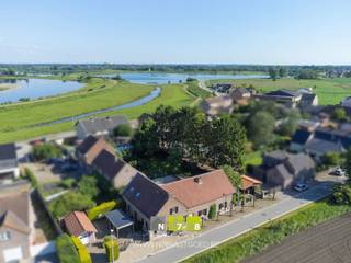 <strong>KARAKTERVOLLE WONING MET 2 VERGUNDE WOONENTITEITEN OP UNIEKE LIGGING AAN DE MAAS TE STOKKEM.</strong><br /><br /><strong>TROEVEN</strong><br />- Rustige en unieke ligging nabij de Maas, natuur en wandelroutes.<br />- 2 Officiële postbussen.<br />- Ideale zorg of kangoeroe woning.<br />- Vergunde 2 woonentiteiten.<br />- Vele belangrijke vernieuwingen.<br />- Vele mogelijkheden voor grote gezinnen, zelfstandigen of combinatie wonen/werken.<br />- Ruim perceel van 12a63ca.<br />- Energielabel C. <br />- Elektrische installatie conform vernieuwd.<br />- Voldoende parkeergelegenheid op eigen terrein.<br /><br /><strong>KELDERVERDIEPING</strong><br />Gewelfde kruipkelder (beperkte ruimte).<br /><br /><strong>GELIJKVLOERS WOONENTITEIT 1</strong><br />Inkomhal (1,15m x 7,90m = 9,09m²): tegelvloer.<br />Toilet: tegelvloer.<br />Woonkamer (4,25m x 6,65m = 28,26m²): tegelvloer.<br />Keuken +veranda (8,60m x 3,00m+ 6,75m x 6,65m = 70,69m²): aansluitingen keukenvoorziening aanwezig, tegelvloer.<br /><br /><strong>GELIJKVLOERS WOONENTITEIT 2</strong><br />Woonkamer (4,65m x 4,50m + 3,30m x 3,00m = 30,83m²): parketvloer.<br />Keuken (4,50m x 4,50m = 20,25m²): geïnstalleerd met onder- en bovenkasten, lades, heteluchtoven, keramische kookplaat, tegelvloer.<br />Berging (3,00m x 3,25m = 9,75m²): cv ruimte, tegelvloer.<br />Badkamer (3,00m x 3,25m = 9,75m²): geïnstalleerd met enkele lavabo, kolomkasten, douche en toilet, tegelvloer.<br /><br /><strong>VERDIEPING +01</strong><br />Open ruimtes staan in verbinding met de 2 woningen, momenteel naar keuze in te delen:<br />Ruimte 1 (11,30m x 5,65m = 63,85m²): momenteel ingericht als slaapkamer, badkamer en berging, plankenvloer.<br />Ruimte 2 (10,85m x 5,50m = 59,68m²): plankenvloer.<br /><br /><strong>EXTERIEUR</strong><br />Garage + carport.<br />Werkplaats + carport.<br />Rustige, omheinde tuin met veel privacy.<br /><br /><strong>RENOVATIES</strong><br />1999-2005 (Vergunning 2 woonentiteiten= totaalrenovatie 2 woningen): elektriciteit, sanitair en leidingwerk, interieur, dak en isolatie, voegwerken gevel.<br />2022: hardhout ramen en deuren, keuken woonentiteit 2.<br /><br />Bekijkt u deze advertentie via een aanverwante vastgoedsite, surf dan zeker naar onze website voor een uitgebreide beschrijving en foto's. Meer info: +32 (0)89 86 18 88 of info@N78vastgoed.be.