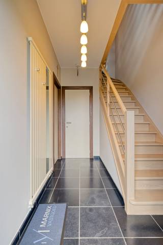 Deze instapklare halfopen bebouwing is rustig gelegen in Holsbeek.<br /> <br />We betreden de woning via de inkomhal met apart gastentoilet. Verder wandelen we door naar de open en volledig geïnstalleerde keuken met aansluitend de ruime en lichtrijke leefruimte. Deze kijkt uit op de gezellige tuin en het terras met overkapping. Verder vinden we op het gelijkvloers een gang met ruimte voor een vestiaire, een praktische berging met aansluiting voor een wasmachine en droogkast en een ruime garage van 32m².<br /> <br />Via de trap bereiken we de eerste verdieping. Deze beschikt over 2 ruime slaapkamers van 45m² en 15m², waarvan 1 slaapkamer met dressing. Verder is er bureau, deze kan eventueel ook als extra slaapkamer dienen. Verder is er een badkamer met bad, douche, enkele lavabo en toilet.<br /> <br />We bereiken de tweede verdieping via een vaste trap naar de zolder. Deze werd reeds omgebouwd naar 2 slaapkamers van elk 10m² en stockageruimtes.<br /><br />De woning beschikt ook over een ruime kelder en een tuinhuis.<br /><br />EPC B. Verwarming is op aardgas. Elektriciteit is niet conform. Asbestveilig.<br />Er zijn 12 zonnepanelen van 2.800 wp. Er is een waterverzachter.<br /><br />Voor meer info of een bezoek ter plaatse, neem gerust contact met ons op!
