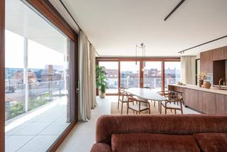 <p>Au sein du superbe projet Portier 51, qui compte 22 appartements, se trouve un penthouse sublime offrant une vue phénoménale sur l'église Notre-Dame-sur-la-Dyle et sur l'élégante maison de concierge, récemment rénovée. L'immense terrasse en forme de L qui entoure l'appartement à l'est et au sud est tout simplement impressionnante. Les finitions soignées et les matériaux haut de gamme utilisés dans ce magnifique appartement sont un véritable régal pour les yeux. Ici, vous vous sentirez vraiment chez vous et pourrez vivre en toute tranquillité au cœur de Malines, à proximité des commerces, des terrasses les plus conviviales, des bars et des restaurants, dans une rue calme et peu fréquentée. Tout est accessible à pied ou à vélo, tandis que la voiture peut être garée confortablement sous le site (moyennant un achat supplémentaire).</p>
<p>AGENCEMENT :</p>
<p>L'appartement est divisé par un vaste hall d'entrée en une aile jour et une aile nuit.</p>
<p>Une porte pivotante en acier donne accès à l’agréable pièce à vivre avec cuisine ouverte, où une magnifique lumière pénètre par les grandes baies vitrées coulissantes en bois. Un superbe îlot de cuisine en noyer avec un plan de travail en pierre naturelle attire tous les regards dans la pièce. La cuisine SieMatic est équipée d’appareils électroménagers haut de gamme de la marque Miele (four à vapeur combiné, four multifonction, réfrigérateur, plaque à induction avec hotte intégrée, lave-vaisselle). Un débarras (technique) très pratique est dissimulé derrière le mur sur mesure. Sur la droite se trouve le bureau avec des étagères, un plan de travail et une armoire de rangement. Grâce à l’utilisation systématique de matériaux haut de gamme, l’ensemble forme un tout harmonieux sur le plan visuel dans tout l’espace de vie. Il y a suffisamment de place pour une grande table et un coin salon confortable. La grande terrasse – en partie couverte – entoure tout l’espace de vie, qui se prolonge ainsi naturellement vers l’extérieur.<br /><br />Une première salle de bains en mortex, dotée des mêmes meubles en noyer et d’un plan de travail en pierre naturelle, est équipée d’un lavabo, de toilettes et d’une douche à l’italienne. Les élégants détails en bronze brossé lui confèrent une allure luxueuse.<br /><br />Près du hall d’entrée se trouvent les toilettes pour invités avec un lavabo. Derrière celles-ci se trouve un deuxième débarras pouvant servir de buanderie.<br /><br />De ce côté se trouvent les 3 chambres, dont la chambre parentale dispose également d’une salle de bains « en suite » entièrement dans le même style que l’autre, avec double lavabo et douche à l’italienne.<br /><br />PRATIQUE :<br /><br />Entièrement conforme aux dernières normes de durabilité : pompe à chaleur géothermique et air-eau, panneaux solaires, isolation, refroidissement passif, système de ventilation D+.<br /><br />Indice énergétique E19. Votre consommation d’énergie est ainsi réduite au minimum. Cela vous permet également d'être exonéré de la taxe foncière pendant 5 ans.<br /><br />Un local à vélos commun est à votre disposition.<br /><br />Le site dispose d’un jardin intérieur élégamment aménagé qui fait référence à l’ancien jardin du couvent. Il est fermé par des portails en bois. Partout, des matériaux de qualité ont été utilisés et les finitions sont soignées, jusque dans les moindres détails, des escaliers dotés de balustrades modernes en bois à la signalisation originale des étages.<br /><br />Charges communes : 295 euros/mois.<br /><br />Il est disponible immédiatement.<br /><br />Le penthouse peut être acheté au taux de TVA de 6 % si les conditions sont remplies.<br /><br />Une place de parking sous le site peut être acquise au prix de 38 000 euros hors TVA.<br /><br />Ce magnifique bien vous intéresse et vous souhaitez le visiter ? N'hésitez pas à contacter Tinne Schotsmans : 0477 60 21 99 ou tinne.schotsmans@quares-trevi.be</p>