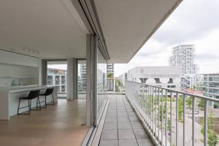 <p>Appartement d’exception dans HAVN – Élégance scandinave au cœur du Zuid<br /><br />Situé dans l’emblématique HAVN, conçu par le célèbre architecte suédois Johannes Norlander, cet appartement remarquable incarne parfaitement l’élégance du design scandinave contemporain. L’immeuble se distingue par son architecture transparente, ses matériaux de grande qualité et son esthétique minimaliste intemporelle.<br /><br />Grâce à ses vastes baies vitrées, l’appartement bénéficie d’une luminosité exceptionnelle tout au long de la journée. La pièce de vie, généreuse et ouverte, est entourée de terrasses qui prolongent naturellement les espaces intérieurs et offrent de belles vues dégagées ainsi qu’une agréable sensation d’espace.<br /><br />La cuisine bulthaup, reconnue pour son design épuré et sa qualité irréprochable, s’intègre harmonieusement à l’architecture du lieu.<br /><br />L’appartement comprend une spacieuse chambre principale ainsi qu’une seconde pièce plus petite, idéale comme chambre d’amis, bureau ou dressing.<br /><br />Idéalement situé dans le très recherché quartier du Zuid, à proximité immédiate des musées, galeries, restaurants et cafés, ce bien constitue un pied-à-terre idéal pour les amateurs d’architecture contemporaine et de vie urbaine raffinée.<br /><br />Une opportunité rare d’acquérir un appartement où lumière, architecture et qualité de vie se conjuguent à la perfection.</p>