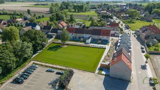 Woonomgeving De Lelie: 18 nieuwbouwwoningen in het landelijke en historische Beauvoorde - REEDS 7 VERKOCHT!<br />Salons De Lelie... Jaren een begrip in Beauvoorde en de héél ruime omgeving als je van plan was om te trouwen, een jubileum of verjaardag te vieren, een souper voor je vereniging te geven of zelfs een galabal van een studentenclub te organiseren. Voor al deze feestelijke aangelegenheden kon je terecht in "De Lelie". <br />Uit deze "gezegende" grond rijzen er heel binnenkort 18 nieuwbouwwoningen. De site is gelegen op de hoek van de Gouden Hoofdstraat en de Vinkemstraat en is gelegen onder het welziend oog van de kerk van Vinkem. Beauvoorde bestaat uit 2 dorpjes: Wulveringem (kant van het kasteel) en Vinkem die gescheiden zijn door de Gouden Hoofdstraat. <br />Beauvoorde is een deelgemeente van Veurne en staat bekend op zijn charmant en poëtisch centrum waarbij het kasteel van Beauvoorde uiteraard dé toerische trekpleister is voor het dorp. Naast een warme bakker, kapsalon, dorpscafé, bloemenwinkel,... biedt Beauvoorde ook tal van hoevewinkels aan waar je verse en lokale producten kan kopen. Door de nabije ligging van de N8 biedt Beauvoorde een vlotte verbinding richting Veurne/E40, de kust maar ook landinwaarts richting Ieper, Poperinge,... <br />Gezien de bouwwerken aan deze site nog maar recent gestart zijn, kan elke woning worden afgestemd op de persoonlijke smaak en wensen van de koper, dit zowel naar afwerking als naar indeling. 17 van de 18 woningen vallen onder de noemer "nieuwbouw", 1 woning valt onder het stelsel van de registratierechten. <br />De woningen worden omgeven door een groene zone waarbij de bewoners kunnen genieten van de rust en de natuur. De site wordt eveneens voorzien van 2 oplaadpalen. <br />De prijzen zijn vanaf € 382.576, exclusief kosten. De lichtrijke woonkamer bestaat uit de zit- en eetplaats en een volledig uitgeruste keuken. Verder op het gelijkvloers is er steeds een ruime berging en een inkomhall met apart toilet. Op de verdiepingen verschilt het aantal slaapkamers van woning tot woning maar sowieso is er een badkamer voorzien met inloopdouche én ligbad en een apart toilet. In de meeste woningen is er reeds een vaste trap voorzien tussen het eerste en het tweede verdiep. Het terras/tuintje is er om te genieten van de gezonde buitenlucht en de zonnestralen. Er is mogelijkheid tot het bijkopen van een autostaanplaats. <br />Verder zitten standaard in de afwerking: regenwaterput van 10.000 liter, warmtepomp, 8 zonnepanelen, volledig uitgeruste keuken, badkamer sowieso met inloopdouche en ligbad, terras in gezaagd polierbeton,... Alles wordt uiteraard volgens de geldende isolatienormen gebouwd: spouw-, muur- én dakisolatie. De fietsenberging en parkomgeving zijn gemeenschappelijke voorzieningen. <br />Nieuwe dronebeelden geven je een prachtig totaalbeeld van het project — AI heeft alvast een handje geholpen om het gras mooi groen aan te leggen<br />Indien aan de voorwaarden voldaan, 6% BTW ipv 21% BTW! <br />Neem zeker contact op om te vernemen wat de overige woningen inhouden! Er is zeker voor elk wat wils in deze woonomgeving De Lelie!