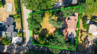 Nabij het kasteel van ’s-Gravenwezel bevindt zich deze karaktervolle Vlassak-Verhulstvilla, waar privacy, ruimte en groen harmonieus samenkomen. De omliggende natuur leent zich uitstekend voor wandelen, fietsen en sporten, terwijl de centra van ’s-Gravenwezel en Schilde zich op korte afstand bevinden. Ook scholen, winkels en openbaar vervoer zijn vlot bereikbaar. Een aangename combinatie van residentieel wonen en vlotte bereikbaarheid.<br /><br /><strong>Indeling</strong><br />Via de automatische toegangspoort bereikt u de villa langs de oprijlaan met voldoende parkeergelegenheid en een dubbele inpandige garage.<br /><br />De centrale inkomhal met vestiaire en gastentoilet geeft toegang tot verschillende vertrekken in de villa. De ruime woonkamer geniet dankzij de vele raampartijen van veel natuurlijk licht en een prachtig zicht over de tuin en terras. Aansluitend bevinden zich de eetkamer en keuken, die samen met de woonkamer rechtstreeks uitgeven op het zonnige terras. Een heerlijke plek voor lange diners, gezellige familiemomenten of het ontvangen van gasten.<br /><br />Naast de keuken bevindt zich een praktische wasplaats/berging met toegang tot de garage, het terras, de bergkelder en de wijnkelder. Het gelijkvloers beschikt daarnaast over twee polyvalente ruimtes, momenteel ingericht als bureau en speel-/hobbykamer, maar flexibel in te vullen volgens uw eigen woonbehoeften.<br />Een absolute troef is de master suite op het gelijkvloers, compleet met dressing, badkamer ensuite en toegang tot een eigen terras.<br /><br /><strong>Verdieping</strong><br />Op de eerste verdieping bevindt zich een tweede master bedroom met dressing en een gezellig privéterras. Daarnaast zijn er nog drie slaapkamers, twee badkamers en een afzonderlijk toilet.<br /><br /><strong>Tuin</strong><br />De zuidgeoriënteerde tuin vormt een prachtig verlengstuk van de woning en biedt verschillende plekken om doorheen de dag van de zon en het groen te genieten. Het overdekte terras met haard creëert een sfeervolle buitenruimte, terwijl het afzonderlijke multifunctionele bijgebouw/poolhouse bijkomende mogelijkheden biedt.<br />Tot slot beschikt de villa over praktische opbergzolders, een berg- en wijnkelder en een kruipruimte onder de volledige woning.<br /><br /><strong>Bijzonderheden</strong><br />+ Vlassak-Verhulstvilla<br />+ EPC: C<br />+ Elektriciteit conform<br />+ Gegeerde ligging nabij het kasteel van ’s-Gravenwezel<br />+ Zuidgeoriënteerde tuin<br />+ 5 slaapkamers en 3 badkamers<br />+ Master bedroom met dressing en badkamer op het gelijkvloers<br />+ Meerdere polyvalente ruimtes<br />+ Dubbele inpandige garage en ruime oprit