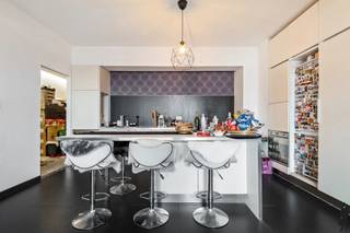 <strong>Twee-slaapkamerappartement tussen stad en park</strong><br /><br />Gelegen op wandelafstand van <strong>Park Den Brandt</strong> en het <strong>Middelheimpark</strong>, combineert deze ligging groene rust met een uitstekende bereikbaarheid. De <strong>A12 richting Brussel</strong> en andere invalswegen liggen vlakbij, <strong>openbaar vervoer </strong>stopt voor de deur en het <strong>Zuid </strong>met haar levendige horeca, winkels en musea bevindt zich op slechts enkele minuten.<br /><br />Het gebouw, daterend uit <strong>1955</strong>, ademt nog de charme van zijn tijd met <strong>authentieke elementen </strong>die mooi bewaard bleven. De gemeenschappelijke delen worden <strong>goed onderhouden</strong>, wat zorgt voor een verzorgde indruk en een aangename woonervaring.<br />Het appartement zelf is <strong>licht </strong>en <strong>zonnig </strong>dankzij de <strong>ongehinderde namiddagzon </strong>en het <strong>vrij uitzicht</strong>. De <strong>praktische inkomhal</strong> biedt plaats voor een vestiaire en geeft toegang tot een <strong>apart toilet</strong>. De <strong>leefruimte met open </strong>keuken voelt ruim aan.<br /><br />Vooraan bevindt zich een <strong>slaapkamer </strong>of <strong>bureauruimte</strong>, uitgerust met een aparte <strong>douchekamer </strong>en wastafel: perfect voor gasten of een kleine praktijk aan huis. Achteraan ligt de <strong>grote slaapkamer met ochtendzon </strong>en rechtstreekse toegang tot de <strong>badkamer </strong>met ligbad.