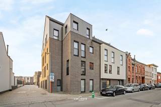 Dit instapklare en zeer recente nieuwbouwappartement (2019) is gelegen in het centrum van Sint-Niklaas, op wandelafstand van de Grote Markt, scholen, winkels en openbaar vervoer. Een uiterst vlotte ligging voor wie comfortabel en centraal wil wonen, maar ook bijzonder interessant als investering.
Het appartement beschikt over meer dan 100 m² bewoonbare oppervlakte en is gelegen op het gelijkvloers, wat zorgt voor maximaal gebruiksgemak: geen lift, geen wachttijden en een vlotte toegankelijkheid. De zeer ruime leefruimte met open keuken vormt het hart van het appartement. De keuken is uitgerust met alle moderne voorzieningen en een ruim werkoppervlak, ideaal voor dagelijks comfort en gezellige momenten.
Verder beschikt het appartement over een handige technische ruimte, een apart toilet en een badkamer met inloopdouche, wat bijdraagt aan het hedendaags wooncomfort. De gezellige buitenruimte met rechtstreekse toegang is een absolute troef, onder meer bij het binnenbrengen van boodschappen of fietsen.
Technisch scoort dit appartement bijzonder sterk: EPC A (ecobouw), ventilatiesysteem C, condensatieketel en conforme elektriciteit.
Een staanplaats wordt mee aangeboden aan €12.500.
Een uitstekende opportuniteit als eigen woning of investering. Snel bij zijn is de boodschap. Bel ons nu voor een afspraak op het nummer: 052/46.38.03 en wie weet tot binnenkort! 
