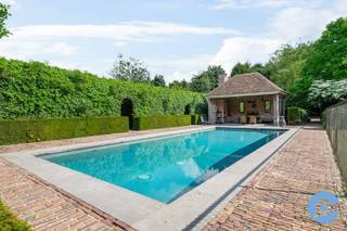 Deze solide en up to date villa ligt op een prachtig met bomen omringd, zuid west gericht perceel van 3.303m2. Het centrum van Edegem en Hove bevinden zich beide op wandel- en fiets afstand. <br /><br />Vanaf u binnenkomt in de royale inkomhal beseft u dat u binnentreedt in ware luxe. De volledige woning werd afgewerkt met de beste materialen en met een uitmuntend oog voor detail.<br /><br />Er is een aparte ontvangstruimte met aansluitend een kantoor met ingebouwde bibliotheek. <br /><br />De leefruimte met open haard heeft een open zicht over de aangelegde parktuin met zwembad en poolhouse. <br />De aangesloten maar afscheidbare eetkamer staat in onmiddellijke verbinding met de ingerichte keuken en bijkeuken.<br /><br />Van hieruit bereikt u tevens de 3 inpandige garages of de volledige kelderverdieping van 250m2. Deze is niet alleen volledig betegeld maar ook verwarmd waardoor ze uitermate geschikt is als fitnessruimte, ontspanningskamer, … Er is ook een gekoelde wijnkelder voorzien voor de liefhebbers.<br /><br />Op de eerste verdieping bevinden zich maar liefst 6 slaapkamers en 3 badkamers. Aan ruimte dus geen gebrek.<br /><br />De aangelegde parktuin huist niet alleen het verwarmd zwembad (12,5m x 5m) maar heeft ook nog een prachtige bbq ruimte met infrarood verwarming en een overdekt terras waar het heerlijk zitten is in elk seizoen. Als extra troef is er nog een aparte guesthouse met eigen keuken, badkamer en slaapkamer.<br /><br />Extra troeven: super ligging – gunstig EPC – 3 inpandige garages – alarmsysteem – elektrische rolluiken – meerdere zonneterrasen – waterontkalker – extra zolderruimte - centraal stofzuigsysteem - geïrrigeerde en verlichte tuin - vloerverwarming - recente verwarmingsketel (2022 - Viessman) - ...<br />