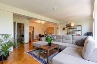 Ligging<br />Op de Franklin Rooseveltlaan, een zeer gegeerde locatie in Gent, vindt u dit ruim appartement met 2 slaapkamers (bvo van 124 m²) . Gelegen aan het Zuidpark en vlakbij het Muinkpark geniet u van een groene oase midden in de stad. Dankzij de nabijheid van de fly-over hebt u directe verbinding met de belangrijkste invalswegen, wat zorgt voor een uitstekende bereikbaarheid. Bovendien hebt u alles binnen handbereik en bevinden zich op wandelafstand onder andere het bruisende stadscentrum, diverse winkels, scholen en openbaar vervoer. <br /><br />Indeling<br />Via de ruime inkomhal, met voldoende plaats voor een vestiairekast, komen we meteen in de lichtrijke leefruimte. Dankzij de grote raampartijen valt het fantastische uitzicht op het Zuidpark nog meer op. In de leefruimte is er voldoende plaats voor een grote zithoek, eetkamer en eventueel nog een leeshoek. Aansluitend op de leefruimte bevindt zich de keuken, die ook rechtstreeks toegankelijk is vanuit de inkomhal en beschikt over een praktische voorraadberging. De inrichting is eenvoudig, maar wordt gekenmerkt door de iconische Cubex-kasten die de typische jaren ’70-uitstraling van het appartement mooi onderstrepen. Verder beschikt het appartement over een apart toilet, een badkamer met ligbad en een dressing die zich eveneens uitstekend leent als bureau. Achteraan zijn er twee volwaardige slaapkamers van circa 11 m² en 14 m². Beide ruimtes bieden dankzij hun volwaardige oppervlakte verschillende mogelijkheden naargelang de woonbehoeften. Vanuit één van de kamers is er een directe toegang tot het zuid-west georiënteerd terras. Het uitzicht maakt het plaatje compleet: de Boekentoren en de Sint-Pietersabdij vormen een schitterend Gents decor. <br /><br />Varia<br />Het appartement werd steeds zeer goed onderhouden en combineert zijn karaktervolle uitstraling met het comfort van vandaag. De aanwezigheid van een afzonderlijke wasruimte en privatieve kelderberging zorgen voor de nodige extra functionaliteit. Bovendien is het mogelijk om optioneel een afzonderlijke ondergrondse garagebox mee aan te kopen. Het EPC-label B bevestigt tot slot de energetisch degelijke basis. <br /><br />Troeven<br />* Schitterende vergezichten<br />* Zeer ruim appartement<br />* EPC-label B<br />* Mogelijkheid tot het aankopen van een garagebox<br /><br />Interesse?<br />Een appartement van dit kaliber en op deze locatie laat zich het best ter plaatse ervaren. Ontdek zelf de ruimte, de lichtinval en vooral het unieke uitzicht dat dit Gentse adres zo bijzonder maakt. Plan vandaag nog uw bezoek met Tim!<br /><br />📞 0487 40 21 28<br />📧 tim@gentill.be