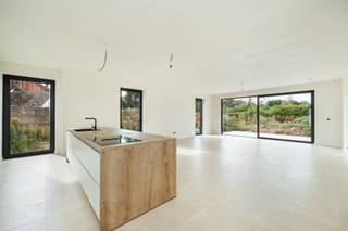 <p><span>In een zone 30, vlakbij het centrum van Hofstade, ligt deze halfopen nieuwbouwwoning met plat dak. Voor en naast de woning kan u een drietal voertuigen kwijt. Er is al een wachtkabel voor een laadpunt aanwezig. Zwarte pvc-ramen contrasteren hier mooi bij de lichte gevelsteen. Dat thema komt terug bij de witte afgewerkte binnendeuren met zwarte klinken. Het energiepeil wordt behaald door integratie van dikke isolatielagen, warmtepomp, algemene vloerverwarming, 5 zonnepanelen (hybride omvormer) en ventilatiesysteem D. De ruime inkom oogt weelderig, dankzij de granieten trapbekleding, grijze vloertegels en een glazen deur naar de living. De leefruimte met open keuken beschikt over een groot schuifraam dat uitgeeft op het betegelde terras en de tuin met groen uitzicht. In de keuken wordt de aandacht getrokken door een groot eiland (zitplaatsen) en volgende apparaten: kookplaat met centrale geïntegreerde afzuiging, koelkast, diepvriezer, oven en combi-/microgolfoven. Let op de verborgen dubbele deur naar de aanpalende berging met uitgietbak. Op de verdieping is nog een bijkomende technische/wasruimte beschikbaar met aansluitingen voor wasmachine en droogkast. In de badkamer is er genoeg plaats voor een acrylbad, een inloopdouche met glazen wand, een dubbel meubel en een hangtoilet. In alle 3 de ruime kamers met waterbestendig laminaat en grote ramen, kan een dubbel bed worden geplaatst. De master bedroom achteraan beschikt over een aanpalende dressingruimte.</span></p>
