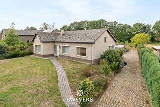 Voor meer info en foto’s, surf naar www.swevers.be – Aan de Heesstraat 32 in Halen bevindt zich deze vrijstaande, gelijkvloerse woning op een uitzonderlijk ruim perceel van 1.754 m². Hier geniet je van veel privacy, een groene omgeving en een vrij uitzicht op agrarisch gebied, terwijl belangrijke verbindingswegen en voorzieningen vlot bereikbaar blijven. De woning werd gebouwd in 1975 en biedt 168 m² bewoonbare oppervlakte. Verdere renovatie geeft nieuwe eigenaars de mogelijkheid om het geheel volledig naar eigen smaak en hedendaagse woonwensen in te richten. De woonkamer van 36 m² biedt plaats voor een comfortabele zit- en eethoek en sluit aan op de open keuken. Verder zijn er drie ruime slaapkamers van 16 m², 14 m² en 16 m², een apart bureau en een centraal gelegen badkamer. Een berging, wasplaats, afzonderlijk toilet, garage voor één wagen en ruime kelder zorgen voor heel wat praktische ruimte. De grote troef is het perceel: rondom de woning is volop plaats om een ruime tuin te creëren en te genieten van rust en groen. Ook leent het perceel zich perfect tot het houden van paarden. Openbaar vervoer bevindt zich op ca. 650 meter en de snelweg op ca. 3,15 km. Een interessante opportuniteit voor wie een vrijstaande woning met ruimte, privacy en renovatiemogelijkheden zoekt. Voor meer informatie, bel 011 255 155. Bron bewoonbare oppervlakte: EPC – verslag. Dit pand is onderworpen aan de renovatieverplichting van de Vlaamse overheid voor residentiële gebouwen (behoudens bij sloop binnen 5 jaar na de aankoop). Consulteer voor meer informatie de website van het Vlaams Energie- en Klimaatagentschap via https://www.vlaanderen.be/een-huis-of-appartement-kopen/renovatieverplichting-voor-residentiele-gebouwen.