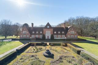 Te midden van een indrukwekkend domein van ca. 6 hectare bevindt zich deze uitzonderlijke family estate in Vlaamse landhuisstijl, ontworpen door architect R. Van de Sompel en gebouwd in 1950. De architectuur combineert de charme van het klassieke Vlaamse landhuis met verfijnde interbelluminvloeden, wat resulteert in een tijdloos geheel met een statige uitstraling.<br /><br />Het domein wordt gekenmerkt door een symmetrische oprijlaan, formele tuinen en uitgestrekte parkaanleg met volwassen bomen, waardoor het geheel een uitzonderlijk gevoel van rust, privacy en grandeur uitstraalt.<br /><br />De villa van 752m2 vormt het hart van het domein en beschikt over een ontvangstruimte, een diner ruimte, 7 slaapkamers en 5 badkamers, aangevuld met een volledig onderkelderd niveau waarin zich de wijnkelder bevindt. <br /><br />De architectuur kenmerkt zich door grote raampartijen, hoge plafonds en een logische circulatie tussen de verschillende leefruimtes, waarbij het zicht op het park voortdurend aanwezig blijft.<br /><br />In de linkervleugel van de villa bevindt zich een personeelsgedeelte met meerdere slaapkamers, een badkamer en een eigen keuken, ideaal voor inwonend personeel, gasten of een uitgebreid gezin.<br /><br />De combinatie van architecturale kwaliteit, omvangrijk terrein en meerdere woonentiteiten maakt dit estate uitzonderlijk veelzijdig. Het domein leent zich perfect voor:<br />- Ondernemers of personen met een vrij beroep die wonen en werken willen combineren in een inspirerende en representatieve omgeving<br />- Vermogende families die een privé estate willen creëren met ruimte voor meerdere generaties<br />- Kopers op zoek naar een specifieke lifestyle, zoals paardenliefhebbers, artiesten of verzamelaars die ruimte, privacy en karakter zoeken<br />De uitgestrekte parktuin, boomgaardstructuren en open graspartijen bieden tal van mogelijkheden voor verdere ontwikkeling van een privé domein op maat van de toekomstige eigenaar.