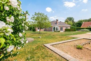 <p>Aan Everdijkruis 26 in Gooreind (Wuustwezel) ontdekt u een laagbouwvilla op een prachtig perceel van maar liefst 2.664 m². De woning beschikt over een bruikbare vloeroppervlakte van 191 m² volgens EPC inclusief de inpandige garage en combineert een sterke betonstructuur met royale ruimtes, veel lichtinval en bijzonder interessante uitbreidingsmogelijkheden. Het interieur is vandaag eerder klassiek, maar met enkele gerichte ingrepen kan deze woning worden omgevormd tot een verrassend hedendaagse en stijlvolle thuis. Om dat potentieel zichtbaar te maken, werden enkele indicatieve renders toegevoegd.<br /><br />U betreedt de woning via de ruime centrale inkomhal, die toegang biedt tot vrijwel alle vertrekken en het afzonderlijke gastentoilet met handenwasser. De leefruimte geniet dankzij de prachtige kamerhoge raampartijen van een overvloed aan natuurlijk licht en voelt bijzonder aangenaam en warm aan. De gezellige houthaard vormt een sfeervolle blikvanger tijdens de koudere maanden. Aansluitend bevindt zich de keuken met kookeiland, uitgerust met onder meer een inductiekookplaat, dampkap, vaatwasser, koelkast en microgolfoven. De keuken sluit aan op de veranda, vanwaar u rechtstreeks de tuin bereikt.<br /><br />Verder beschikt het gelijkvloers over twee ruime slaapkamers van circa 12 en 15 m² en een comfortabele badkamer met ligbad, afzonderlijke douche, toilet en dubbele wastafel. Via de berging, die tevens dienstdoet als technische ruimte en wasplaats, bereikt u de dubbele inpandige garage van maar liefst 32 m². Bovendien is de woning volledig onderkelderd, waardoor u over veel extra stockage- en bergruimte beschikt.<br /><br />Een absolute meerwaarde is de ruime zolderverdieping, die zich uitstrekt over nagenoeg het volledige gelijkvloers. Momenteel bereikt u deze via een uitklapbare vouwtrap, maar in de ruime inkomhal is plaats om eventueel een vaste trap te voorzien. De zolder is reeds volledig geïsoleerd en beschikt over twee grote dakvensters. Wenst u extra slaapkamers, een thuiskantoor, hobbyruimte of speelkamer? Dan biedt deze verdieping uitzonderlijk veel mogelijkheden. Dankzij de betonstructuur beschikt u bovendien over een solide basis om deze ruimte verder in te richten.<br /><br />Ook technisch beschikt de woning over interessante troeven. Het EPC vermeldt een label D met een energiescore van 350 kWh/(m² jaar). Met enkele kleine energetische ingrepen kan de energieprestatie verder worden verbeterd. Daarnaast is de woning asbestveilig. Dankzij haar bijzonder degelijke constructie beschikt de woning over een uitstekende basis om het interieur volledig naar uw eigen smaak en woonstijl te verfijnen.<br /><br />De ligging aan het Everdijkruis biedt u een heerlijk gevoel van ruimte, groen en privacy. De volledig omheinde tuin vormt een veilige en aangename plek waar jong en oud volop kan genieten. Er is meer dan voldoende ruimte voor een groot speeltuig voor de kinderen, terwijl u op zonnige dagen gezellig samenkomt voor lange zomeravonden en barbecues met familie en vrienden. Dankzij het royale perceel kunt u de tuin bovendien volledig naar uw eigen wensen vormgeven, terwijl u toch vlot verbonden blijft met de voorzieningen van Gooreind en de omliggende gemeenten. Een ideale omgeving voor wie rustig en ruim wil wonen zonder aan bereikbaarheid in te boeten.<br /><br />Bent u op zoek naar een woning die u volledig naar uw eigen smaak kunt transformeren en die bovendien met u kan meegroeien? Dan nodigen wij u graag uit om deze villa persoonlijk te komen ontdekken.</p>