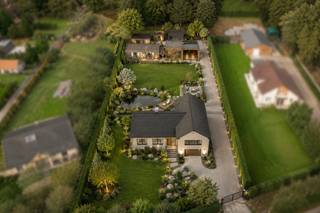 <p>Bent u op zoek naar een te renoveren woning of bouwgrond met tal van mogelijkheden, gelegen op een groot perceel en met een vlotte bereikbaarheid? Dan is dit eigendom beslist een bezoekje waard. De woning is steeds goed onderhouden en biedt royale volumes, 4 slaapkamers en een aangename tuin met prachtig uitzicht. Houd er rekening mee dat de woning dient gerenoveerd te worden en onder de <strong>renovatieplicht</strong> valt: binnen de 6 jaar na aankoop dient zij energetisch gerenoveerd te worden tot minstens een <strong>EPC-score D</strong>. Een ideale opportuniteit voor wie wil wonen in een groene omgeving met alle rust en privacy.</p>
<p><strong>GELIJKVLOERS</strong><br />U betreedt de woning via een ruime inkomhal van 10 m² op tegel. Ook via een achteringang van 5 m² heeft u bijkomende toegang.<br />De woonkamer van 42 m² op tegel is uitgerust met een pelletkachel.<br />Aansluitend bevindt zich een veranda van 23 m² op tegel waar u kan genieten van een wijds uitzicht.<br />De keuken van 20 m² is volledig uitgerust met inductieplaat, koelkast, vaatwasser, microgolfoven, heteluchtoven, dampkap, dubbele spoelbak en een praktische koffiecorner.<br />Verder vindt u op het gelijkvloers een wasplaats met douchekamer van 16 m², een bureel van 9 m² en een garage van 32 m² met automatische toegangspoort.</p>
<p><strong>TUIN EN BUITENRUIMTE</strong><br />De woning beschikt over een <strong>uitzonderlijk grote</strong> tuin met vijver, ideaal om in alle rust te genieten van het buitenleven.<br />Daarnaast is er een duivenhok met een oppervlakte van 40 m², dat ook andere invullingen kan krijgen.</p>
<p><strong>KELDER / KRUIPRUIMTE</strong><br />Praktische kelder- en kruipruimte van 17 m² op tegel, ingericht als bergkelder en technische ruimte.</p>
<p><strong>1STE VERDIEPING</strong><br />Op de eerste verdieping bevindt zich een overloop van 7 m² die toegang geeft tot drie volwaardige slaapkamers van respectievelijk 15 m², 16 m² en 13 m², allen afgewerkt met vinyl.<br />De badkamer van 8 m² is voorzien van een ligbad, enkele lavabo en toilet.</p>
<p><strong>2DE VERDIEPING</strong><br />De tweede verdieping omvat een overloop van 5 m² op vast tapijt, een vierde slaapkamer van 24 m², een berging van 8 m² en een extra zolderruimte van 20 m². Deze verdieping biedt bijkomend uitbreidingspotentieel.</p>
<p><strong>BIJZONDERHEDEN</strong><br />CV op mazout met ondergrondse stookolietank, thermostatische kranen, geboorde waterput (90 m diep), regenwaterput met inhoud 2.000 liter), automatische toegangspoort, dubbele beglazing, rolluiken, videofoon.</p>
<p><strong>POSTIEVE PUNTEN<br /></strong>Weids uitzicht<br />Veel parkeergelegenheid<br />Nabij invalswegen en autosnelwegen<br />Vier slaapkamers en twee badkamers<br />Grote, functionele ruimtes met enorm potentieel</p>