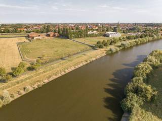 Exclusieve Kans in het Hart van de Leievallei! Wij presenteren met trots deze uitzonderlijke landelijke eigendom, gelegen aan de Bondgenotenlaan en de Leie in Kuurne. Met een totale grondoppervlakte net geen 4 hectare (39.924 m²), biedt dit unieke pand een zeldzame combinatie van natuur, ruimte en mogelijkheden. De eigendom grenst aan de Leie en het jaagpad, en kijkt uit op de prachtige Heulebeekvallei, wat zorgt voor een ongeëvenaard uitzicht en een rustige, landelijke sfeer.<br />Sfeerfilm: https://youtu.be/U5SBKlvnXKY<br /><br />Strategische Ligging en Bereikbaarheid. <br />De locatie van deze eigendom is ongeëvenaard. Gelegen op de overgang tussen het natte valleilandschap van het waterpark en de open ruimte van de Leiemeersen, biedt het zowel privacy als directe toegang tot de natuurlijke schoonheid van de regio. Toch bent u slechts enkele minuten verwijderd van het centrum van Kuurne en belangrijke verbindingswegen, waardoor steden zoals Kortrijk en Harelbeke snel bereikbaar zijn. Dit maakt het pand ideaal voor wie rust en het landelijke zoekt zonder in te boeten op bereikbaarheid.<br /><br />Veelzijdige Bestemmingsmogelijkheden<br />De eigendom valt onder het BPA (Bijzonder Plan van Aanleg) dat als hoofdbestemming oa recreatie, sport en gemeenschapsvoorzieningen voorschrijft. Daarnaast zijn ook wonen en horeca als nevenfunctie mogelijk. Deze veelzijdigheid opent tal van mogelijkheden.<br />Momenteel is er op het terrein een paardenmanège, wat aangeeft dat de locatie al geschikt is voor activiteiten die harmonieus samengaan met de natuurlijke omgeving. Daarenboven zijn er 3 ruime hangars aanwezig op het terrein die beschikken over royale volumes en zijn voorzien van meerdere stallingen alsook een ruime binnenpiste.<br /><br />Onderdeel van het Masterplan 'Vlaspark'<br />Deze eigendom maakt deel uit van het ambitieuze masterplan 'Vlaspark', dat gericht is op de ontwikkeling van een duurzaam en geïntegreerd landschap. De strategische ligging op de overgang tussen het waterpark en de Leiemeersen onderstreept de waarde van deze site binnen het bredere regionale plan. Investeren in deze eigendom betekent deel uitmaken van een toekomstgerichte visie voor Kuurne en omstreken.<br /><br />Kortom, deze landelijke eigendom biedt een zeldzame kans om te investeren in een uitzonderlijk vastgoed met ongekende mogelijkheden. Of u nu een visionair project wilt ontwikkelen, een oase van rust zoekt of een strategisch gelegen commerciële exploitatie overweegt, deze locatie heeft het allemaal.<br /><br />Neem contact met ons op voor meer informatie of om een bezichtiging in te plannen. Dit is een kans die u niet wilt missen!<br /><br />Onze ref. DEV5123