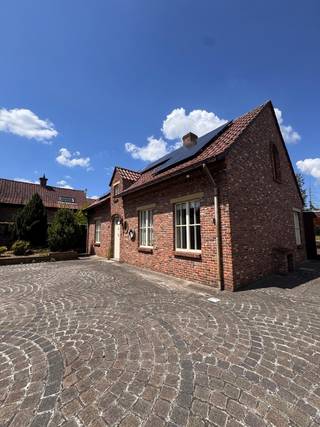 Bent u op zoek naar een charmante hoeve met veel ruimte en eindeloze mogelijkheden? Dan is deze uitzonderlijke fermette precies wat u zoekt! Ideaal voor wie nood heeft aan ruime garages, bergingen, magazijnen of een combinatie van wonen en werken. Indeling: Via de inkomhal met ruimte voor een vestiaire bereikt u een apart gastentoilet. Op het gelijkvloers vindt u verder een bureauruimte of extra slaapkamer, een gezellige woon- en eetkamer, een badkamer met douche en toilet, een ruime tweede slaapkamer, een bijzonder grote keuken, een praktische berging en een indrukwekkend ruime, lichtrijke veranda waar het heerlijk vertoeven is. Buiten beschikt het eigendom over twee ruime garages en een grote schuur met tal van mogelijkheden, ideaal voor opslag, hobby's of een zelfstandige activiteit. De woning is omgeven door een verzorgde tuin en ligt op een perceel van ca. 1.600 m², waar u in alle rust kunt genieten van de buitenruimte. Interesse? Neem gerust contact op voor meer informatie of een vrijblijvend plaatsbezoek via 0488/60.05.07.