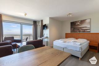 Centraal gelegen <strong>één</strong> <strong>slaapkamer</strong> appartement met zicht op zee.<br /><br />Bij het binnenkomen komt u meteen terecht in de <strong>lichtrijke</strong> <strong>leefruimte</strong> met rechtstreekse toegang tot het <strong>ruime</strong> <strong>terras</strong> waar u kunt genieten van een prachtig panoramisch zicht over de zee. Aanpalend met de leefruimte situeert zich de slaapkamer, momenteel voorzien van een stapelbed. Verder bestaat het appartement nog uit een <strong>badkamer</strong> met <strong>douche</strong> en <strong>toilet</strong>.<br /><br />Het appartement is gelegen op de <strong>elfde</strong> <strong>verdieping</strong> in een gebouw op de Zeedijk genaamd "Suitehotel Ocean" en is bereikbaar met de <strong>lift</strong>. Dankzij de <strong>centrale</strong> <strong>ligging</strong> dichtbij de haven en de markt zijn alle nutsvoorzieningen in de buurt.<br /><br />Het appartement wordt verkocht onder de formule van erfpacht. Dit biedt verschillende voordelen, zoals een <strong>lagere</strong> <strong>aankoopprijs</strong> gezien de grond niet aangekocht wordt. Voor het gebruik van de grond betaalt de erfpachter aan de grondeigenaar een jaarlijkse som geld, ook wel canon genoemd. Deze canon is <strong>fiscaal</strong> <strong>aftrekbaar</strong>. <br />Momenteel wordt het appartement verhuurd via een hotelpoule die de suite verhuurt op vakantiebasis, waarop de eigenaar een percentage van de winsten verkrijgt. Het is ook mogelijk om zelf de suite te reserveren voor eigen gebruik. De eigenaar is bereidt de kost om uit de hotelpoule te stappen voor zich te nemen.<br /><br />Het is niet mogelijk zich hier te domiciliëren, het appartement kan enkel gebruikt worden als <strong>vakantieverblijf</strong>.