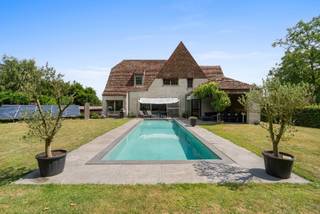 <strong>--- NIEUW --- Exclusieve villa te Drongen (verkoop onder registratierechten).</strong><br /><br /><strong>👉 U kan de vastgoedvideo terugvinden via onze eigen website www.vastgoedspruyt.be.</strong><br /><br /><strong>Algemeen;</strong><br />Zeer mooie volwaardige nieuwbouwvilla (bj. 2012), gelegen op een rustige locatie en op wandelafstand van het dorpscentrum. De woning heeft een bewoonbare oppervlakte van zo'n 322m² + (wijn)kelder 32m² + (berg)zolder 37m² + (dubbele)garage 140m². Gelegen op een perceel van 1.907m²,<br /><br /><strong>Indeling;</strong><br />De woning heeft een lichtrijke eetruimte en leefruimte met gashaard en zicht op de Zuid-West gerichte tuin. De open keuken heeft een kookeiland, uitgevend op terras en tuin. Gelijkvloers is er ook een afzonderlijke wasplaats en berging, kelder, inkomhal, gastentoilet en een afzonderlijke bureau (met afzonderlijke ingangmogelijkheid). Op de verdieping zijn er 4 volwaardige slaapkamers, een ruime dressing en 2 badkamers. Afzonderlijk toilet en een zolderluik. Ruime oprit met carport voor 2 wagens én extra bergruimtes.<br /><br /><strong>Bijkomende troeven;</strong><br />- Verwarmd overloopzwembad (3.5*12.5m).<br />- Zéér energiezuinige woning (EPC A = 55kWh/m² - E-peil=36)!<br />- 15 zonnepanelen.<br />- Warmtepomp voor verwarming van het zwembad.<br />- Gelijkvloerse vloerverwarming.<br />- Regenwaterpomp.<br />- Conforme (elektrische) keuringen.<br />- Vliegenramen en ingebouwde verlichtingsarmaturen.<br />- Rustige en vlot bereikbare ligging met commerciële troeven.<br />- ...<br /><br /><strong>De verkoopdocumenten zijn ter inzage via: https://vastgoedspruyt.sharepoint.com/:f:/g/IgCcO05vFNXbToL3wachRxfdAW2egelBFZNBTj-xHBtJkXs?e=B5RaqE</strong><br /><br /><strong>Interesse in deze unieke opportuniteit?<br />📞 Contacteer Michel Spruyt via 09/311.89.90<br />🌐 Of vraag uw bezoek aan via www.vastgoedspruyt.be</strong><br /><br />Vg, Wg, Gmo, Gvkr, Vv. Asbestvrije woning - Geen beschermd monument - Geen bouwkundig erfgoed - Overstromingsgevoeligheid; P & G-score; A.<br /><br />