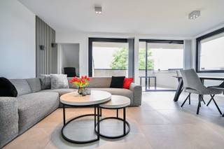 Te midden van de Boomstraat in Bornem, op wandelafstand van winkels, horeca en openbaar vervoer, bevindt zich dit prachtige volledig bemeubelde dakappartement. Hoewel het appartement nog nooit werd bewoond, is het reeds volledig ingericht en afgewerkt, waardoor het onmiddellijk instapklaar is.<br />Bij de afwerking werd veel aandacht besteed aan comfort en energiezuinigheid. De warmteproductie gebeurt via een warmtepomp in combinatie met zonnepanelen en aangename vloerverwarming die zowel kan warmen als koelen. Daarnaast beschikt het appartement over een individuele ventilatie van type C.<br />Het appartement omvat een ruime slaapkamer met aansluitende, volledig ingerichte dressing, een stijlvol afgewerkte badkamer met inloopdouche, een apart gastentoilet en een praktische berging voorzien van wasmachine en droogkast. De volledig uitgeruste keuken sluit naadloos aan op de lichtrijke woonkamer, waar maatwerk aanwezig is in de vorm van een tv-meubel en een ingebouwd bureau. Het appartement werd volledig geschilderd en voorzien van gordijnen, zodat u zonder bijkomende investeringen meteen kunt verhuizen.<br />Verder beschikt u over een mooi zonnig terras waar het heerlijk vertoeven is. Fietsen kunnen veilig worden gestald in de fietsenberging en voor extra opslagruimte is er een private kelderberging of een zolderruimte van ongeveer 50 m² beschikbaar.<br />Als extra troef geniet u bovendien nog gedurende vijf jaar van een vermindering op de onroerende voorheffing. Dit appartement combineert een uitstekende centrale ligging met hedendaags wooncomfort, een energiezuinige uitrusting en een hoogwaardige afwerking, waardoor het een unieke opportuniteit vormt voor wie op zoek is naar een zorgeloze en instapklare woonst in het centrum van Bornem.<br /> 