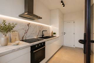 Dit smaakvol vernieuwde appartement is gelegen aan het Sporthalplein 148, op de 10de verdieping, en geniet van prachtige open zichten. Dankzij de terrassen aan zowel de voor- als achterzijde kan u op elk moment van de dag genieten van zon en uitzicht.<br /><br />Het appartement werd grondig gerenoveerd met onder meer nieuwe ramen, vernieuwde sanitaire afvoeren, een volledig nieuwe elektriciteit die conform is voor de komende 25 jaar, en een kwalitatieve afwerking doorheen het hele appartement.<br /><br />De indeling omvat een inkomhal met beveiligde deur, een apart gastentoilet, een moderne badkamer met inloopdouche en een lichtrijke leefruimte. De nieuwe, moderne keuken geeft rechtstreeks toegang tot het terras en biedt een aangename verbinding met buiten. Aansluitend bevindt zich een praktische berging, ideaal voor onder andere wasmachine en droogkast. Verder zijn er twee ruime slaapkamers, geschikt voor dubbele bedden.<br /><br />Daarnaast genieten bewoners van gemeenschappelijke autostaanplaatsen vlak voor de deur, exclusief voor de residentie, wat zorgt voor extra comfort. Een privatieve berging op niveau -2 is inbegrepen, ideaal voor bijkomende opslagruimte.<br /><br />Dankzij de nieuwe ramen behaalt het appartement een gunstige EPC-score met label B.<br /><br />Ideaal als investering of als comfortabele eigen woonst.