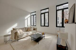 In het hart van Antwerpen bevindt zich dit hoogwaardig gerenoveerde appartement op de eerste verdieping. Een unieke woonbeleving waar elegantie, comfort en licht harmonieus samenkomen.<br /><br />Bij binnenkomst wordt u meteen verwelkomd door een gevoel van ruimte en rust. De afwerking werd met uiterste zorg gekozen, waarbij natuurlijke materialen, zachte kleuren en een tijdloos design zorgen voor een stijlvolle en serene woonomgeving.<br /><br /><span><strong>INDELING</strong></span>:<br /><br />Via de inkomhal betreedt u de uitzonderlijk lichtrijke leefruimte, waar grote raampartijen een overvloed aan natuurlijk licht binnenbrengen en een aangename sfeer creëren. <br /><br />De open leefruimte vloeit moeiteloos over in de volledig geïntegreerde designkeuken, uitgerust met kwalitatieve toestellen en verfijnde maatkasten in warme houttinten. <br /><br />De aansluitende eetruimte vormt een elegante plek om te tafelen en gasten te ontvangen.<br /><br />Het appartement beschikt over ruime, rustig gelegen slaapkamers die uitnodigen tot ontspanning. <br /><br />De badkamer werd afgewerkt met oog voor detail en biedt een stijlvolle inloopdouche en hoogwaardige materialen. <br /><br />Verder is er een apart gastentoilet en een praktische bergruimte aanwezig.<br /><br /><span><strong>BIJZONDERHEDEN</strong></span>:<br /><br />- Volledig en kwalitatief gerenoveerd met oog voor detail<br />- Gelegen op de eerste verdieping (zonder lift)<br />- Uitermate lichtrijk dankzij grote raampartijen<br />- Hoogwaardige, duurzame materialen en verfijnde afwerking<br />- Gegeerde centrumligging nabij winkels, gastronomie en openbaar vervoer