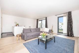 À deux pas de l’OTAN, dans un immeuble récent de 2012, découvrez ce bel appartement de ± 81 m², alliant confort moderne, fonctionnalité et luminosité.<br /><br />Dès l’entrée, un hall de jour avec WC invités mène vers un agréable séjour de ± 40m², baigné de lumière et ouvert sur une cuisine américaine équipée, idéale pour partager des moments conviviaux au quotidien. L’appartement dispose également d'une chambre à coucher, d’une salle de bains, d’une buanderie ainsi que de deux belles terrasses de ± 14m² chacune, parfaite pour profiter d’un extérieur en toute tranquillité.<br /><br />Le bien est complété par des équipements appréciables tels que des placards intégrés, la vidéophonie, une cave n° 21 et un emplacement de parking intérieur n° 10, proposé en supplément au prix obligatoire de 20.000 €.<br /><br />Actuellement loué 1.072€/mois, cet appartement représente aussi une belle opportunité d’investissement. Bail de 9 ans en cours depuis le 15/08/2018.<br /><br />Charges : ± 120 €/mois comprenant l’assurance, le syndic, les communs et l’entretien.<br />PEB : B-<br /><br />Un bien soigné, pratique et bien situé, idéal pour habiter ou investir dans un environnement recherché.<br /><br />Mesures données à titre indicatif.