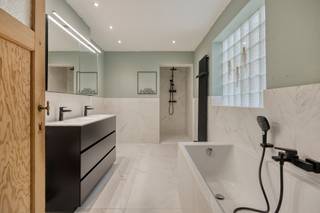 <p><em>Deze gezellige stadswoning op een </em><strong><em>perceel van 2a30ca</em></strong><em> beschikt over een bewoonbare oppervlakte van 160 m² en is rustig gelegen, op wandelafstand van het stadscentrum, scholen en dagelijkse voorzieningen. De woning combineert authentieke charme met hedendaags wooncomfort en is ideaal voor wie centraal én rustig wil wonen.</em></p><p>De hoge plafonds creëren een aangenaam gevoel van ruimte. De kwalitatieve <strong>Dovy-keuken met lichtstraat</strong> zorgt voor een mooie natuurlijke lichtinval. Vanuit de keuken is er rechtstreeks toegang tot het terras en de tuin. De badkamer beschikt over zowel een ligbad als inloopdouche.<br />De originele deuren tussen keuken en eetkamer werden door de eigenaar zorgvuldig bewaard.<br />Op de verdieping bevinden zich <strong>twee ruime slaapkamers</strong> met plankenvloer.<br />De <strong>zolderruimte</strong> hoeft slechts beperkt afgewerkt te worden en biedt bijkomende mogelijkheden. De laminaatvloer is beschikbaar via de eigenaar.<br />Stockeren? Een handige berging en kelder zijn aanwezig.<br />Via de keuken bereik je rechtstreeks het zonnige terras, tuin en speelbos.</p>