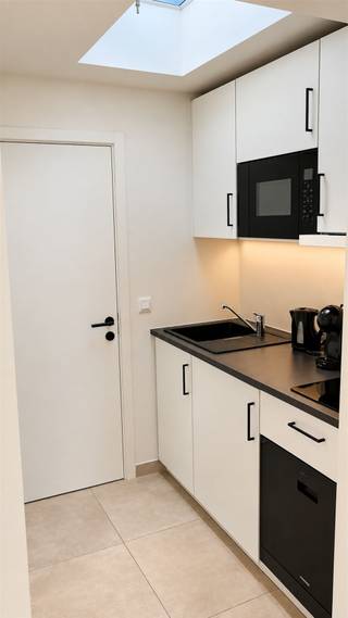 <p><span>De Kattenbleekstraat combineert een centrale ligging  met stilte in een doodlopende straat. Het wit/zwart thema is doorgetrokken in de hele woning: van de witte sierpleister en zwarte ramen van de voorgevel tot de witte muren en zwarte accenten binnen in huis. Dat dit een kwaliteitsvolle renovatie (2025) is geweest, kan u zien aan de gebruikte materialen: aluminium met driedubbel glas, 2 aparte hangtoiletten, LED-plafondspots, 2 airco-units met warmtepomptechnologie, etc.  Op het gelijkvloers leiden de open structuur en hoge plafonds tot een gezellige sfeer. De open keuken met lichtkoepel, omvat een kookplaat, microgolfoven, vaatwasser en koelkast. De verdiepingstrappen met hun houten treden op een metalen structuur, accentueren verder het open aspect op beide verdiepingen, waar telkens één slaapkamervertrek (waterbestendige PVC-vloeren) is ondergebracht. In de goed geventileerde badkamer is plaats genoeg voor een douchecel (regenfunctie) met glazen wand en een lavabomeubel met spiegelkast. Qua bergruimte spotten we een gelijkvloerse berging en een technische berging (2</span><span><sup>e</sup></span><span> verd.), met daarin de elektrische boiler. Ook de elektriciteit, de technieken en de riolering werden vervangen. De haast perfecte officiële Mobiscore van 9,6 op 10, bewijst dat u hier desgewenst perfect kan wonen zonder auto. De Kattenbleekstraat heette vroeger “Kattenstrate”, maar draagt al sinds de 14</span><span><sup>e</sup></span><span> eeuw de huidige naam. Waarschijnlijk liet men er linnen drogen of bleken in de zon.</span></p>
