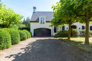 Deze villa geniet van een uitstekende ligging in een doodlopende straat, midden in een groene villawijk van ’s-Gravenwezel. Het dorpscentrum met winkels, horeca, scholen en dagelijkse voorzieningen bevindt zich op korte afstand, terwijl ook Schilde en de omliggende gemeenten vlot bereikbaar zijn. Een aantrekkelijke woonomgeving waar het groene karakter en een uitstekende bereikbaarheid mooi samenkomen.<br /><br /><strong>Indeling</strong><br />Via de oprijlaan met voldoende parkeergelegenheid bereikt u de villa, die toegankelijk is via zowel de centrale inkomhal als de dubbele inpandige garage.<br />De inkomhal met vestiaire en gastentoilet leidt naar de gezellige zithoek met houthaard en aansluitende eetkamer. Daarnaast bevindt zich een polyvalente ruimte, momenteel ingericht als tweede zithoek, maar eveneens geschikt als bureau, lees- of hobbyruimte.<br />De grote raampartijen zorgen voor een overvloed aan natuurlijk licht en bieden vanuit de leefruimtes een prachtig zicht op het terras, de vijver en de fraai aangelegde tuin.<br />Aansluitend aan de eetkamer bevindt zich de uitgeruste keuken met veranda. Dankzij het panoramische zicht over de tuin vormt deze een aangename extra leefruimte. Vanuit de keuken bereikt u tevens de dubbele garage, voorzien van extra bergruimte en aansluitingen voor wasmachine en droogkast.<br /><br /><strong>Verdieping</strong><br />Op de eerste verdieping bevinden zich drie volwaardige slaapkamers, waarvan twee zeer ruim en voorzien van ingemaakte kasten. De master bedroom beschikt over een badkamer (recent gerenoveerd) ensuite met ligbad, douche, lavabo en toilet, evenals een riant privéterras.<br />Daarnaast is er op deze verdieping een afzonderlijk toilet aanwezig.<br />Tot slot beschikt de woning over een praktische opbergzolder, wijnkelder en kruipruimte.<br /><br /><strong>Tuin</strong><br />De fraai aangelegde tuin geniet van een uitstekende zuidoriëntatie en vormt een mooie aanvulling op de leefruimtes. Het terras met vijver creëert een sfeervolle plek om van de tuin te genieten, terwijl achteraan het perceel nog een praktisch tuinhuis aanwezig is.<br /><br /><strong>Bijzonderheden</strong><br />+ Deze architecturale werd in 1976 gebouwd door architect Laporta<br />+ Conforme elektrische installatie<br />+ Gegeerde residentiële ligging<br />+ Zuidgeoriënteerde tuin<br />+ 3 volwaardige slaapkamers<br />+ Dubbele inpandige garage<br />+ Dak recent vernieuwd en geïsoleerd<br />+ Wijnkelder en praktische opbergzolder<br /> 