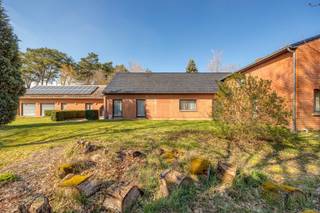 Kijkmoment op vrijdag 19 juni - graag telefonisch bevestigen via 03 289 11 00.<br /><br />Deze vrijstaande woning ligt op een centrale locatie in Tremelo, omgeven door groen. Via een mooie oprijlaan kom je uit aan de achtergelegen open bebouwing, gelegen op een perceel van ca. 3400m². Met de nabijheid van het centrum, van vlotte verbindingen naar Mechelen, Leuven of andere invalswegen én tal van wandel- en fietsmogelijkheden in de streek, is de ligging van dit pand een grote troef. De streek staat bekend om haar rustige karakter en mooie natuur.<br /><br />De woning beschikt over een ruime gelijkvloerse indeling, met inkomhal, een lichtrijke woon- en eetkamer, een keuken met aansluitend een veranda, een apart toilet, een douchekamer, een bergruimte, een masterbedroom met ensuite badkamer en nog 2 volwaardige slaapkamers. De bovenverdieping bestaat uit nog eens 3 slaapkamers en een zéér grote zolderverdieping met potentieel tot extra kamers. Verder zijn er 3 garages en zeer veel atelier- en bergruimte.<br /><br />Troeven: prachtige groene ligging - veel mogelijkheden qua indeling - zonnepanelen - 6 volwaardige slaapkamers - ruimte voor het parkeren van meerdere wagens - belangrijkste ruimtes op de gelijkvloerse verdieping, wat potentieel biedt voor woon-werk combinatie of kangoeroe woning.