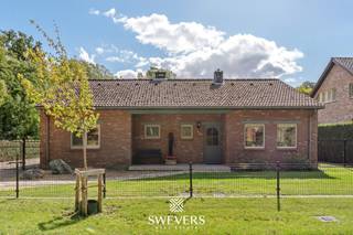 Voor meer info en foto’s, surf naar www.swevers.be – In een rustige, groene straat in het hart van Leopoldsburg ontdek je deze instapklare bungalow op een perceel van 42a 10ca. De woning is volledig gelijkvloers, gebouwd in 1989 en piekfijn onderhouden. Met een bewoonbare oppervlakte van 161 m², een ruime zolder van 128 m² en een droge kruipkelder biedt ze comfort en uitbreidingsmogelijkheden. De leefruimte van 32 m² baadt in natuurlijk licht en sluit aan op een open keuken van 24 m² met zicht op de zuidgerichte tuin. Verder zijn er drie slaapkamers (14 m², 12 m² en 6 m²), een badkamer met ligbad, douche en dubbele lavabo, en een praktische berging met toegang tot het terras. Buiten geniet je van een prachtig aangelegde tuin met een vrijstaande garage en ruime oprit. Alle dagelijkse voorzieningen vind je op amper 3 km afstand, met vlotte verbinding naar de autosnelweg. Voor meer informatie, bel 011 255 155. Bron bewoonbare oppervlakte: EPC – verslag.