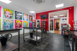 <p>Op sommige plekken in Antwerpen hoef je de locatie nauwelijks nog uit te leggen.<br />De Kloosterstraat kent iedereen. Antiek, design, kleine boetieks, koffie, restaurants en altijd wel iets te ontdekken. En net om de hoek, in de Korte Vlierstraat, staat dit karaktervolle handelshuis.<br />Een pand met 294 m² ruimte, een flinke dosis persoonlijkheid en vooral: mogelijkheden.</p>
<p>We beginnen beneden.<br />Vandaag bevindt zich hier een chocoladeatelier. En eerlijk? Dat klinkt op zich al behoorlijk goed.<br />Maar het handelsgelijkvloers hoeft uiteraard niet naar chocolade te blijven ruiken. Met zijn grote open ruimte en etalage aan de straatzijde kan je hier heel wat kanten uit. Een winkel, atelier, showroom, kantoor, praktijk, creatieve studio… Wie droomt van een eigen zaak met een sterke zichtbaarheid en een toplocatie, mag hier alvast beginnen dromen. En bovendien zijn hier 2 wc's voorzien.<br />Achteraan bevindt zich een keuken en dankzij de aparte meters kan het handelsgedeelte bovendien mooi functioneren naast het woongedeelte.</p>
<p>En dan gaan we eerst even naar de kelder.<br />Geen plek waar je tussen spinnenwebben en oude verfpotten naar de watermeter moet zoeken. Hier werden de authentieke bakstenen gewelven net uitgespeeld en kreeg de ruimte zowaar een eigen bar.<br />Een verborgen plek onder de stad, ideaal als extra ontspanningsruimte, wijnkelder of gewoon als die plek waar een avond soms iets langer duurt dan gepland.</p>
<p>Vanaf de eerste verdieping begint het privéleven.<br />En na de uitgesproken commerciële ruimte beneden verandert de sfeer hier helemaal. Een ruime leefkamer met houten vloer biedt plaats aan zowel salon als eetkamer. De open keuken is gloednieuw (2024), uitgerust met gootsteen, inductiekookplaat (4 pitten) en ingebouwde dampkap.</p>
<p>Aansluitend ligt een gezellige buitenruimte. Een groen hoekje midden in de stad om heerlijk te genieten van een tasje koffie, aperitief in de zon of gewoon vijf minuten eens helemaal niets te doen.</p>
<p>Op de 2de verdieping bevindt zich de grote slaapkamer met aparte dressing en daarnaast een ruime badkamer. En ook die past helemaal bij het karakter van het huis: een groot ligbad, aparte douche en een eigenzinnige zwart-witte vloer.</p>
<p>Helemaal boven wachten nog twee kamers.<br />Slaapkamers, hobbyruimtes,… kies maar.<br />En dan is er nog het uitzicht.<br />Want boven de daken krijg je Antwerpen er zomaar bij. Met onder andere de kathedraal aan de horizon. Niet slecht als achtergrond bij je eerste koffie van de dag.</p>
<p>De Kloosterstraat ligt letterlijk om de ene hoek, de Sint-Andriesplaats om de andere hoek. De vernieuwde Scheldekaaien en het Zuidpark zijn vlakbij en voor leuke winkels, koffie of een goed restaurant hoef je hier zelden ver te wandelen. Bovendien zijn er plannen om de straat als woonerf in te richten.</p>
<p>Dit is dan ook geen woning die zich makkelijk in één vakje laat stoppen.<br />Het is een handelspand, een woning, een werkplek en vooral een plek met karakter.</p>
<p>Troeven:<br />– toplocatie <br />– handelsgelijkvloers, huidige eigenaars zijn bereid dit te huren tegen marktconforme voorwaarden, valt zeker en vast te bespreken!<br />– aparte meters <br />– buitenruimte <br />– kelder met bar <br />– airco <br />– EPC C, inclusief 12 zonnepanelen<br />- Prachtig uitzicht</p>