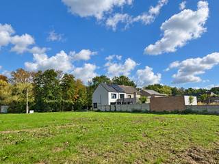 Op een vlot bereikbare locatie tussen het centrum van Berlaar en Itegem bevindt zich deze ruime bouwgrond voor open bebouwing. Winkels, scholen, openbaar vervoer en andere dagelijkse voorzieningen zijn vlot bereikbaar. Tegelijk geniet u hier van een groene omgeving met verschillende wandel- en fietsmogelijkheden in de buurt.<br /><br />Lot 1 maakt deel uit van een goedgekeurde verkaveling voor zes vrijstaande eengezinswoningen. Het perceel heeft een totale oppervlakte van 1.079 m², een straatbreedte van circa 21,50 meter en een diepte van ongeveer 50 meter. Dankzij deze ruime afmetingen zijn er heel wat mogelijkheden voor het bouwen van een volwaardige gezinswoning met een mooie tuin.<br /><br />De woning dient op 8 meter van de rooilijn te worden ingeplant. Aan beide zijden geldt een bouwvrije strook van 4 meter, waardoor een maximale bouwbreedte van circa 13,50 meter mogelijk is.<br /><br /><strong>Bouwmogelijkheden:</strong>
<ul>
<li><span>Gelijkvloerse verdieping: maximaal 13,50 meter breed en 17 meter diep, goed voor circa 229,50 m²</span></li>
<li><span>Eerste verdieping: maximaal 13,50 meter breed en 13 meter diep, goed voor circa 175,50 m²</span></li>
<li><span>Tweede verdieping: maximaal 13,50 meter breed en 9 meter diep, goed voor circa 121,50 m²</span></li>
<li><span>Theoretisch maximaal bruto vloeroppervlak van circa 526,50 m²</span></li>
<li><span>Maximale kroonlijsthoogte van 6 meter</span></li>
<li><span>Maximale nokhoogte van 11 meter</span></li>
<li><span>Keuze tussen een plat dak of een hellend dak met een maximale dakhelling van 45°</span></li>
</ul>
De bouwgrond is bestemd voor een vrijstaande eengezinswoning, eventueel aangevuld met maximaal één zorgwoning. Een beperkte nevenbestemming voor een vrij beroep of dienstverlening is mogelijk, voor zover de woonfunctie behouden blijft. De nevenbestemming mag maximaal 100 m² van de totale vloeroppervlakte innemen.<br /><br />De garage dient inpandig in de woning te worden voorzien. Daarnaast moet er voldoende ruimte aanwezig zijn voor het stallen van fietsen.<br /><br />In de tuinzone mogen bijgebouwen worden opgericht met een gezamenlijke oppervlakte van maximaal 75 m² en een maximale hoogte van 3 meter. De overige verhardingen in de tuinzone worden beperkt tot maximaal 100 m², met uitzondering van de noodzakelijke oprit en het toegangspad naar de woning. De oprit dient aan de rechterzijde van het perceel te worden aangelegd.<br /><br />Daarnaast bestaat de mogelijkheid om het volledige achtergelegen agrarische perceel van 3.911,30 m² apart bij aan te kopen. Samen met de bouwgrond bedraagt de totale oppervlakte dan maar liefst 4.990,30 m². Op het bijkomende perceel blijft de agrarische bestemming van toepassing.<br /><br /><strong>Troeven:</strong>
<ul>
<li><span>Vlotte verbinding met Berlaar en Itegem</span></li>
<li><span>Ruim perceel van 1.079 m²</span></li>
<li><span>Geschikt voor een vrijstaande woning</span></li>
<li><span>Perceelbreedte van circa 21,50 meter</span></li>
<li><span>Maximale bouwbreedte van circa 13,50 meter</span></li>
<li><span>Tot circa 526,50 m² bruto vloeroppervlakte mogelijk</span></li>
<li><span>Keuze tussen een plat of hellend dak</span></li>
<li><span>Ruime mogelijkheden voor tuin en bijgebouwen</span></li>
<li>Mogelijkheid tot aankoop van 3.911,30 m² achtergelegen agrarisch gebied</li>
</ul>
De vermelde oppervlaktes zijn theoretische maxima op basis van de geldende verkavelingsvoorschriften. Het uiteindelijke bouwvolume is steeds afhankelijk van het concrete ontwerp en de goedkeuring van de bevoegde diensten.<br /><br />Voor meer informatie kunt u contact opnemen met VB Vastgoed via 03 337 50 70 of info@vbvastgoed.be.
