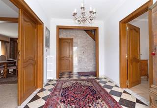 <p><span>Deze ruime woning is gebouwd in ±1966 en is gelegen op een perceel van ±13a 87ca. </span></p><p><span> </span></p><p><span>Via een automatische poort bereikt u de ruime parking aan de woning. </span></p><p><span> </span></p><p><span>Vanuit de inkomhal met gastentoilet krijgt u toegang tot het ruime leefgedeelte, bestaande uit een gezellige living met haard (±33m²), een eetplaats en een afzonderlijke tv-hoek (±27m²). Aansluitend bevindt zich de leefkeuken met achterliggende bijkeuken (±21m²). Verder beschikt het gelijkvloers over een afzonderlijke bureauruimte (±12m²), een berging (±8.5m²) en een wasplaats (±6m²) met rechtstreekse toegang tot het terras. </span></p><p><span> </span></p><p><span>Op de verdieping bevinden zich vijf slaapkamers (±12.5m², 16.5m², 11m², 11m² en 10.5m²). De masterbedroom geeft toegang tot een terras en geniet van een mooi uitzicht over de tegenoverliggende velden. Daarnaast beschikt één slaapkamer over een eigen douche en wastafel, terwijl een andere slaapkamer voorzien is van een wastafel. De badkamer is uitgerust met een ligbad, wastafel en toilet. (±10.5m²)</span></p><p><span> </span></p><p><span>Verder beschikt de woning over een driedubbele inpandige garage, een kleine kelder en is voorzien van een volledige kruipkelder.</span></p><p><span> </span></p><p><span>Dankzij de ruime indeling en de zuidwestelijke oriëntatie biedt deze eigendom van heel wat mogelijkheden.</span></p><p><span> </span></p><p><span>Extra's: 4 parkeerplaatsen, alarmsysteem, airco, ramen in aluminium (2012), volledig omheind, deuren en trap in massief eikenhout, haard, natuursteen, septische put, ...</span></p><p><span> </span></p><p><span>Uitbreiding garage 1973.</span></p><p><span>Uitbreiding zithoek, berging en wasplaats 1980.</span></p><p><span> </span></p>