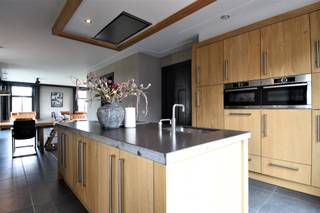 Deze recente woning biedt enorm veel ruimte en is heerlijk rustig gelegen met een fantastisch uitzicht over de velden. Hou je van natuur? Dan is deze ligging ideaal voor jou!<br /><br />Indeling:<br /><br />Gelijkvloers:<br />De achterinkom is gelegen aan de zijkant van de woning. Hier is een apart toilet en ruime wasplaats met douche. De keuken is voorzien van een granieten werkblad en is luxueus ingericht met een inductievuur met 6 kookzones, vaatwasser, koelkast, combi-oven, combi-stoomoven en een cooker. De leefruimte is open waardoor de keuken, eetkamer en woonkamer naadloos in elkaar doorlopen. Vanuit de woonkamer heb je een prachtig eindeloos zicht op de tuin en velden.<br />Verder is er op het gelijkvloers nog een ruimte die kan dienen als bureau, een kelderruimte om wat voorraad te stockeren, een 2de apart toilet in de grote inkomhal en een vestiaire.<br /><br />Verdieping:<br />De masterbedroom is extra ruim en uiterst gezellig door het hoge plafond en de schuine wanden. De 2de slaapkamer heeft aansluitend een dressing/bergruimte. Verder zijn er nog 2 slaapkamers, een kleine bergruimte, apart toilet en een badkamer met ligbad, dubbele wastafel en inloopdouche. <br /><br />Zolder:<br />Via een vaste trap bereik je de gigantische zolderverdieping. Deze kan je gebruiken als hobbyruimte/extra slaapkamer/bureau/...<br /><br />Tuin:<br />Fantastische zuidwest tuin met groot terras en magnifiek uitzicht over de velden. Heerlijk vertoeven hier!<br /><br />Bijzonderheden:<br />- Vloerverwarming over de ganse woning<br />- Warmtepomp<br />- zonnepanelen<br />- Landelijke ligging<br />- Beschikbaar in overleg<br />- Gordijnen + verlichting aanwezig