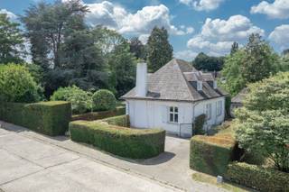 <p><strong>Karaktervolle villa op rustige, residentiële ligging in Schepdaal</strong></p>
<p>In een aangename en rustige straat, vlakbij belangrijke invalswegen, treffen we deze statige villa op een perceel van 10 are. De woning dateert uit 1965 en biedt een solide basis voor wie op zoek is naar ruimte, charme en een rustige, groene omgeving.</p>
<p>De villa bevindt zich in een degelijke staat, al is een <strong>energetische renovatie</strong> vereist. Zo zijn onder meer de dakconstructie, verwarmingsketel en enkele houten ramen met enkel glas toe aan vernieuwing.</p>
<p><strong>Indeling</strong><br />Via de ruime inkomhal bereik je de grote en lichtrijke leefruimte met eetplaats, salon met houtcassette en een aangename bureauhoek. De gesloten keuken werd in 2017 vernieuwd en biedt alle comfort.<br />De mooie houten trap brengt je naar de eerste verdieping met afzonderlijk toilet, drie slaapkamers (12,5m², 14m² en 15m²) waarvan enkele met ingebouwde kasten, een vernieuwde douchekamer (3 m²) en een ruime badkamer.<br />De zolder is bereikbaar via een uittrekbare trap en kan gebruikt worden als stockagezolder.</p>
<p>De kelderverdieping is bijzonder praktisch ingedeeld en omvat een inpandige garage (ca. 22 m²), een wijn-/proviandkelder (9 m²) en een royale wasplaats (25 m²).</p>
<p>De leefruimte sluit naadloos aan op het zonnige terras en de achterliggende tuin met volgroeide bomen. Van hieruit heb je eveneens toegang tot het afzonderlijke garagegebouw, die ook kan worden ingericht als atelier, bergplaats of poolhouse.</p>
<p><strong>EPC:</strong> 877 kWh/m²/jaar – Klasse F<br /><strong>Elektriciteit:</strong> niet conform<br /><strong>Asbestattest:</strong> niet asbestveilig</p>
<p>Deze karaktervolle villa vormt een uitstekende opportuniteit voor wie wil investeren in een ruime woning op een toplocatie in Schepdaal, met alle troeven om er een prachtige, toekomstgerichte thuis van te maken.</p>