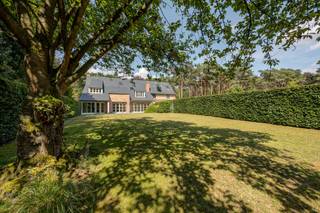 <p>Verscholen in een groene villawijk, in een autoluwe en doodlopende straat in Pulle bevindt zich deze karaktervolle koppelvilla van 255m² (indic. volgens EPC), die uitblinkt in wooncomfort, privacy en een kwalitatieve afwerking. Hierdoor vormt deze woning de ideale thuis voor wie opzoek is naar een exclusieve woonomgeving zonder in te boeten aan bereikbaarheid. <br /><em>[MEER INFO EN FOTO’S op onze website]</em></p>
De woning beschikt over 3 tot 4 volwaardige slaapkamers, 2 badkamers en een polyvalente ruimte die perfect kan dienen als bureau, hobby ruimte of extra slaapkamer. Daarnaast biedt de zolder, bereikbaar via een vaste trap, nog tal van mogelijkheden.<br /><br />GLV: Royale inkomhal met gastentoilet en polyvalente ruimte (bureau of slaapkamer). Via de glazen deur bereikt u de lichtrijke en bijzonder ruime leefruimte, waar een stijlvolle inbouwcassette afgewerkt met een kalkstenen schouwmantel en ingebouwde wandkasten; voor een warme en gezellige sfeer zorgt. Dankzij de grote raampartijen geniet u hier van een overvloed aan natuurlijk licht en een mooi zicht op de tuin. Aansluitend bevindt zich de volledig uitgeruste, gesloten keuken met ruime berging/ wasplaats en toegang tot de veranda. V1: De vide zorgt voor een ruimtelijk gevoel en geeft de nachthal toegang tot alle vertrekken. De masterbedroom beschikt over een eigen dressing en een privatieve badkamer. Daarnaast zijn er nog 2 ruime slaapkamers en een tweede badkamer. V2: Een nog in te richten zolder dat de mogelijkheid biedt voor een extra slaapkamer, etc.<br /><br />
<p>Ook buiten heeft deze woning heel wat te bieden. Via een automatische toegangspoort bereikt u de woning langs een stijlvolle oprijlaan. Vanuit de leefruimte heeft u toegang tot het terras en de verzorgde tuin. De beplanting rondom de woning wordt ondersteund door een geïntegreerd irrigatiesysteem dat doorloopt tot in de voortuin, waardoor het onderhoud van de tuin aanzienlijk wordt vergemakkelijkt. Achter het ruime bijgebouw bevindt zich nog een tweede tuingedeelte met een prachtige grote vijver, waardoor het perceel een bijzonder groen en uniek karakter krijgt. Het multifunctionele bijgebouw omvat een dubbele garage (47m²), een carport (18m²) en een atelier (19m²), waardoor er meer dan voldoende plaats is voor wagens, opslag en diverse hobby- of werkactiviteiten.</p>
BIJZONDERHEDEN:<br />Lichtrijke woning – Dak met natuurleien – Ruime slaapkamers – Ruime en droge kelder - Multifunctioneel en ruim bijgebouw - Unieke perceelsoppervlakte – EPC label B: 188 kWh/m² UC: 3932533 – Pscore: B - Gscore: A – Stedenbouwkundige info in aanvraag