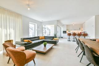 In het charmante Wenduine, op een toplocatie vlak bij de zeedijk en de tennisvelden, verrijst dit exclusief nieuwbouwproject - Residentie “Ace” - dat uitblinkt in woonkwaliteit, duurzaamheid en comfort. Dit ruime appartementen met 2 slaapkamers biedt een royale oppervlaktes van 120 m². Dankzij de toepassing van geothermie en energiezuinige vloerverwarming geniet je van een constante temperatuur met een minimaal verbruik.<br /><br />De architectuur is open en doordacht: het gebouw is volledig rondom vrijstaand en mooi doorgemetseld, wat niet alleen zorgt voor optimale lichtinval via grote raampartijen, maar ook voor uitzonderlijke privacy en panoramische uitzichten. Het appartement beschikt over een ruim overdekt terras van 8 m² - perfect om in alle seizoenen van buitenruimte te genieten. Daarnaast is er een gemeenschappelijk betegeld dakterras van 125 m² met een prachtig zicht op de omliggende natuur, de tennisvelden en de nabijgelegen zeedijk.<br /><br />Niet alleen de ligging en het ontwerp maken dit appartement bijzonder, ook de materialen waarmee gebouwd wordt, zijn van topkwaliteit. Zowel in de ruwbouw als in de afwerking werd bewust gekozen voor duurzame, hoogwaardige materialen die garant staan voor een lange levensduur en een verfijnde uitstraling.<br /><br />Daarnaast is er binnen het project ook aandacht besteed aan groenvoorzieningen en parkeergelegenheid. U heeft de optie om een private staanplaats en/of berging aan te kopen.<br /><br />Dit appartement is ideaal voor wie op zoek is naar een luxueus tweede verblijf, een comfortabele vaste woonplaats aan de kust of een waardevaste investering op een toplocatie. Hier woon je in alle rust, met ruimte, licht en natuur om je heen - en toch op wandelafstand van het strand en het dorpscentrum.<br /><br />Het appartement wordt verkocht onder het BTW-stelsel en komt in aanmerking voor het verlaagde tarief van 6% (mits het voldoen aan de voorwaarden). <br /><br />Aarzel niet en contacteer ons vandaag nog voor een bezoek ter plaatse!