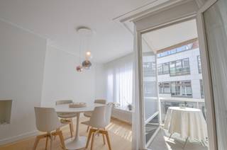Appartement élégant et entièrement rénové à distance de marche de la mer.<br /><br />Cet appartement intemporel, récemment entièrement rénové, bénéficie d’un emplacement exceptionnel, à deux pas de la mer et du centre commercial. Il a été fini avec des matériaux durables et de haute qualité, ainsi qu’un sens du détail remarquable.<br /><br />Dès l’entrée, vous découvrez un hall élégant avec toilette invités, agrémenté d’un mur arrière en marbre de Carrara, d’un WC suspendu Kartell Laufen en blanc mat et d’un lave-mains Falper avec robinetterie RVB. Le hall dispose également d’armoires encastrées.<br /><br />Le séjour spacieux et lumineux est aménagé avec un parquet en chêne de Studio Piet Boon et une cheminée décorative. De grandes baies vitrées offrent une luminosité optimale et donnent accès à la terrasse ensoleillée à l’avant.<br /><br />La cuisine entièrement équipée, réalisée sur mesure par Decota, est dotée d’un plan de travail et d’une crédence en pierre naturelle Emperador Perla Beige, sablée et brossée. Elle comprend des appareils de qualité, tels que :<br /><br />un lave-vaisselle A+++ avec technologie de séchage au zéolite (vaisselle extra sèche), particulièrement silencieux et pilotable via l’application Home Connect ;<br /><br />un four combiné vapeur encastré avec fonction fullSteam, sonde de température à cœur, capteur de cuisson, nettoyage hydraulique et commande via l’application Home Connect.<br /><br />Une buanderie pratique avec raccordements pour machine à laver et sèche-linge est également présente, ainsi que des prises intégrées, coax et UTP de « rond by prado ».<br /><br />L’appartement dispose d’une chambre principale avec armoires encastrées et accès à la terrasse située à l’arrière, ainsi que d’une deuxième chambre. La salle de douche moderne est élégamment aménagée avec des matériaux haut de gamme.<br /><br />Enfin, une cave privative spacieuse et un local à vélos commun facilement accessible complètent cet appartement.