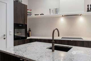 <p><span>Unieke charme, een hoogwaardige renovatie en een uitstekende ligging: deze karaktervolle stadswoning heeft het allemaal. Gelegen in een rustige, verkeersluwe straat woon je hier midden in de stad, met een school op 10m afstand en vlakbij winkels, horeca en openbaar vervoer. Ook de Ring en de stadsrand bereik je in een mum van tijd. De ideale uitvalsbasis voor wie het bruisende stadsleven wil combineren met rust en comfort.</span></p><p><span>De woning werd in 2021 volledig gerenoveerd met oog voor detail en afgewerkt met duurzame, kwalitatieve materialen. Daarbij werden onder meer de leidingen, elektriciteit, verwarming, vloeren, bezetting en de daken volledig vernieuwd. Voor zo veel mogelijk lichtinval werd er een skylight met hoogrendementsglas boven de keuken en tweede verdieping geplaatst. Daarnaast zijn de tussenvloeren geïsoleerd, werd de achtergevel in 2023 extra geïsoleerd en geniet je van een gunstige EPC-score B. Vooraan op het gelijkvloers zijn bovendien elektrische rolluiken voorzien en doorheen de woning is er ingebouwde Serax-verlichting aanwezig.</span></p><p><span>Via de stijlvolle inkomhal met elegante rasico-afwerking bereik je de gezellige leefruimte met open keuken van 47 m². De hoogwaardige afwerking met kalkbepleistering, eikfineer, graniet en microtopping zorgt voor een stijlvolle, warme en eigentijdse uitstraling. De open keuken is volledig uitgerust met kwalitatieve AEG-toestellen, Novy dampkap en een Quooker kraan. Op het gelijkvloers bevindt zich eveneens een apart gastentoilet.</span></p><p><span>De eerste verdieping omvat een ruime slaapkamer van 18 m² met een op maat gemaakte ingebouwde kast. Daarnaast bevindt zich de luxueuze badkamer van 11 m² met vrijstaand bad, inloopdouche, dubbele lavabo en toilet. De vloer-en muurafwerking in de badkamer is voorzien van microtopping. Op de bovenverdieping bevindt zich de royale masterbedroom van 35 m², die eenvoudig kan worden opgesplitst in twee volwaardige slaapkamers. Tot slot beschikt de woning nog over een praktische kelder van 30 m².</span></p><p><span>Ben je op zoek naar een instapklare stadswoning boordevol karakter, met een unieke afwerking en hedendaags wooncomfort? Mis deze kans niet! Voor meer info of een gratis schatting surf naar www.hansimmo.be</span></p><p><span> </span></p>