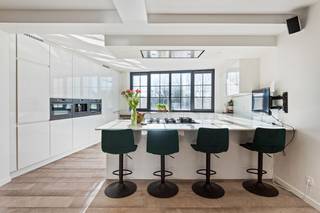 Dit uitzonderlijk duplex appartement is gelegen langs de Turnhoutsebaan in Schilde, een locatie die vlot bereik combineert met een aangename, residentiële omgeving. Op wandel- en fietsafstand bevinden zich buurtwinkels, scholen, openbaar vervoer en diverse horecazaken. Het centrum van Schilde met zijn groene karakter, parken en recreatiemogelijkheden ligt vlakbij, terwijl ook de verbinding naar Antwerpen en Turnhout bijzonder vlot is.<br /><br />Bij het betreden van het appartement komt u binnen via een ruime inkomhal met vestiaire en tegelvloer. Van hieruit leidt de trap naar de leef verdieping, waar een tweede inkomhal toegang geeft tot de verschillende ruimtes. De open leefruimte vormt het hart van het appartement en bestaat uit een ruime eetruimte en een lichtrijke leefruimte met parketvloer en airconditioning. Aansluitend bevindt zich de volledig ingerichte keuken met kookeiland, uitgerust met oven, koelkast, microgolf, diepvries, wijnkoelkast, gasvuur en dubbele spoelbak. De leefverdieping beschikt verder over een aparte bureauruimte met ingemaakte kasten, airconditioning en directe toegang tot het terras, ideaal voor wie wonen en werken wil combineren. Daarnaast zijn er een gastentoilet met handenwasser, een praktische technische berging en een centrale hal met ingemaakte kasten.<br /><br />Op de bovenverdieping bevindt zich een nachthal die toegang geeft tot meerdere slaapkamers. De master bedroom wordt aangevuld met een aansluitende dressing. Daarnaast zijn er nog twee volwaardige slaapkamers, waarvan één met ingemaakte kasten en airconditioning, en een tweede dressingruimte. De stijlvolle badkamer is uitgerust met ligbad, inloopdouche en dubbele wastafel. Verder is er een aparte toiletruimte en een wasplaats.<br /><br />Het zonnige terras vormt een aangename buitenruimte waar het rustig vertoeven is. Tot slot heeft u achter het eigendom op het gelijkvloers een ruime berging voor het stallen van fietsen en de vuilbakken.<br /><br />Een unieke woonopportuniteit voor wie op zoek is naar comfort, ruimte en bereikbaarheid in het hart van Schilde.<br /><br />Troeven:<br />+ EPC A<br />+ Elektriciteit conform<br />+ Zonnepanelen<br />+ Gerenoveerd in 2021<br />+ Aparte inkom<br />+ 4 slaapkamers<br />+ Zeer veel ingemaakte kasten<br />+ Hyper geïnstalleerde keuken<br />+ Centrale locatie<br /><br />Heeft u interesse in dit uniek duplex appartement? Contacteer ons snel op 03 337 50 70 of via info@vbvastgoed.be