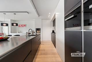 Dit uitzonderlijk ruim en luxueus appartement is gelegen in residentie Park Leopold II 1 te Wenduine op de eerste verdieping en op een rustige ligging net buiten het centrum. Dankzij de samenvoeging van twee appartementen geniet dit eigendom van een bijzonder royale bewoonbare oppervlakte van maar liefst 146 m². Bovendien werd voor de inrichting en afwerking samengewerkt met een architect, wat resulteert in een feilloos afgewerkt en modern geheel met een stijlvolle uitstraling.<br /><br />Bij het betreden van het appartement springt de hoogwaardige afwerking meteen in het oog. De ruime inkomhal, voorzien van praktische ingemaakte kasten, vormt de perfecte binnenkomer en biedt toegang tot de verschillende ruimtes van het appartement. Via een elegante deur bereikt men de leefruimte waar een organische overgang en het grote schuifraam zorgen voor een bijzonder open en lichtrijk gevoel.<br /><br />De woonkamer werd uiterst doordacht ingericht met een gezellige zithoek, een geïntegreerde bureauruimte en een centrale boekenkast die op subtiele wijze de scheiding vormt tussen de eetplaats en de leefruimte. De stijlvolle open keuken is uitgerust met alle moderne comfort en hoogwaardige toestellen. Eyecatcher van de ruimte is zonder twijfel de gezellige gashaard die extra sfeer creëert. Centraal in de keuken bevindt zich bovendien een praktische berging waar niet alleen extra opbergruimte voorzien werd, maar waar ook alle technische installaties van het appartement netjes gecentraliseerd zijn.<br /><br />Via de leefruimte bereikt men de eerste ruime slaapkamer, die beschikt over een ensuite badkamer met douche, lavabo en toilet. Aan de andere zijde van het appartement bevinden zich nog twee volwaardige slaapkamers, beide voorzien van ingemaakte kasten en met toegang tot het tweede terras van het appartement. Verder is er nog een tweede badkamer aanwezig, uitgerust met een inloopdouche en dubbele lavabo. In de inkomhal bevindt zich bovendien nog een apart gastentoilet.<br /><br />Het appartement beschikt over dubbele beglazing, individuele centrale verwarming op aardgas en conforme elektriciteit. Dankzij de gunstige EPC-score vormt dit appartement niet alleen een stijlvolle, maar ook energiezuinige woonoplossing.<br /><br />Ten slotte bevindt zich in de kelderverdieping ook een dubbele garage, die verplicht aan te kopen is voor 100.000 EUR.<br /><br />Kortom, een unieke kans voor wie op zoek is naar een luxueus afgewerkt appartement met royale volumes, veel lichtinval en een uitstekende ligging aan de Belgische kust. Ideaal als vaste woonplaats, tweede verblijf of investering. Plan nu uw bezoek in!<br /><br />