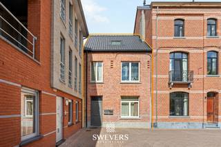 Voor meer info en foto’s, surf naar www.swevers.be – In het hart van Leopoldsburg, aan het Koningin Astridplein 20, bevindt zich dit interessante opbrengsteigendom met twee ruime, momenteel verhuurde appartementen. Het gebouw dateert oorspronkelijk uit 1918 en werd grotendeels gerenoveerd in 2018, waarbij belangrijke structurele werken zoals nieuwe ramen, een nieuw dak, … reeds werden uitgevoerd. Aparte meters voor gas en water ondersteunen de opdeling in twee wooneenheden. Het gelijkvloerse appartement beschikt over een inkomhal, een living en leefruimte van ca. 28,8 m², een keuken van ca. 8,4 m², badkamer, cv-ruimte, slaapkamer van ca. 12,1 m² en een afzonderlijke berging. Achteraan is er toegang tot een eigen koer. Het tweede appartement strekt zich uit over de eerste en tweede verdieping. Op de eerste verdieping bevinden zich een living, aparte keuken, badkamer, slaapkamer van ca. 15,2 m² en berging. De bovenste verdieping telt nog twee ruime slaapkamers van ca. 22,8 m² en 18 m². In totaal beschikt het gebouw over vijf slaapkamers. De centrale ligging is een belangrijke troef. Winkels, kinderopvang en ontspanning liggen op ca. 150 meter, openbaar vervoer op amper 145 meter en scholen op ca. 540 meter. Dankzij de twee verhuurde appartementen, praktische indeling en renovaties vormt dit pand een interessante opportuniteit voor investeerders. Voor meer informatie, bel 011 255 155.