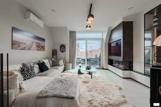 Prachtig afgewerkt duplex appartement in zeer recent gebouw ( opgeleverd in 2022) op topligging, midden in de winkelstraat en vlakbij de Zeedijk. Indeling : woonkamer bestaande uit zeer ruime zithoek voorzien van elektrische haard, uitgevende op het zonnige terras aan de voorzijde ( zon van 11u tot 's avonds) met zijdelings zicht op zee en voorzien van automatische zonneluifel, grote luxekeuken met groot eiland en voorzien van alle inbouwtoestellen, eethoek met aansluitend terrasje aan acherzijde waar men de ochtendzon heeft, 2 toiletten, berging met aansluiting voor wasmachine en droogkast, luxe badkamer voorzien van ligbad, inloopdouche en dubbel lavabo, 2 slaapkamers waarvan 1 extra ruime slaapkamer. Gelijkvloerse ruime gemeenschappelijke fietsenberging en privatieve kelderberging op het gelijkvloers. Zeer gunstig epc label A en conforme elektrische installatie. Topafwerking voorzien van maatkasten, lucht-warmtepompen, automatisch bedienbare rolluiken. Topaanbieding op superligging. Het appartement wordt ongemeubeld verkocht. Het meubilair en inrichting kan overgenomen worden mits bespreking met de eigenaar.