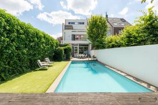 <p><span> </span></p><p><span>Architectenwoning met zwembad, 285 m² bewoonbare oppervlakte en 3 garages op rustige toplocatie in het centrum van Diest</span></p><p><span> </span></p><p><span>Op een rustige en gegeerde locatie, vlak bij scholen, winkels, het station, de ziekenhuis site en belangrijke invalswegen, bevindt zich deze uitzonderlijke architectenwoning met een bewoonbare oppervlakte van maar liefst </span><span>285 m²</span><span>. De woning combineert een doordachte indeling met hoogwaardige afwerking en een overvloed aan natuurlijk licht dankzij de grote raampartijen.</span></p><p><span> </span></p><p><span>Bij het betreden van de woning komt u terecht in een ruime inkomhal met een praktische vestiaire en een apart gastentoilet. De keuken ligt in het hart van de woning en is voorzien van alle hedendaagse comfort. Aansluitend bevindt zich een wasplaats met handige berging. De ruime leefruimte baadt in het daglicht en biedt een aangenaam zicht op de tuin, waardoor binnen en buiten naadloos in elkaar overvloeien.</span></p><p><span> </span></p><p><span>Op de eerste verdieping bevindt zich de royale master bedroom met een aparte dressing en een stijlvolle, kwalitatief afgewerkte badkamer. Daarnaast is er een ruime overloop die momenteel praktisch is ingericht als bureauruimte, ideaal voor thuiswerk of een studeerhoek.</span></p><p><span> </span></p><p><span>De tweede verdieping beschikt over twee volwaardige slaapkamers, elk voorzien van een eigen inloopdouche en wastafel. Daarnaast is er een mezzanine die eenvoudig kan worden afgesloten, waardoor er een vierde én vijfde slaapkamer beschikbaar zijn. Op deze verdieping geniet u bovendien van een aangenaam dakterras.</span></p><p><span> </span></p><p><span>Ook buiten heeft deze woning heel wat te bieden. De zonnige, perfect georiënteerde tuin met verwarmd zwembad garandeert maximale privacy en vormt de ideale plek om in alle rust te ontspannen. Achteraan het perceel bevinden zich drie afzonderlijke garages en een parkeerplaats, elk voorzien van een automatische sectionaalpoort.</span></p><p><span> </span></p><p><span>Extra troeven:</span></p><ul><li><span>Architectenwoning met 285 m² bewoonbare oppervlakte;</span></li><li><span>Rustige ligging nabij alle voorzieningen;</span></li><li><span>Volledig onderkelderd dat kan dienen als werkruimte;</span></li><li><span>Verwarmd zwembad;</span></li><li><span>Drie garages en een extra parkeerplaats </span></li><li><span>Gunstig EPC;</span></li><li><span>Asbestveilig;</span></li><li><span>Elektrische installatie conform de huidige regelgeving.</span></li></ul><p><span> </span></p><p><span>Bent u op zoek naar een ruime, instapklare gezinswoning met een hoogwaardige afwerking, veel lichtinval en alle hedendaagse comfort op een uitstekende locatie in Diest? Dan is deze unieke eigendom absoluut een bezoek waard.</span></p><p><span> </span></p>